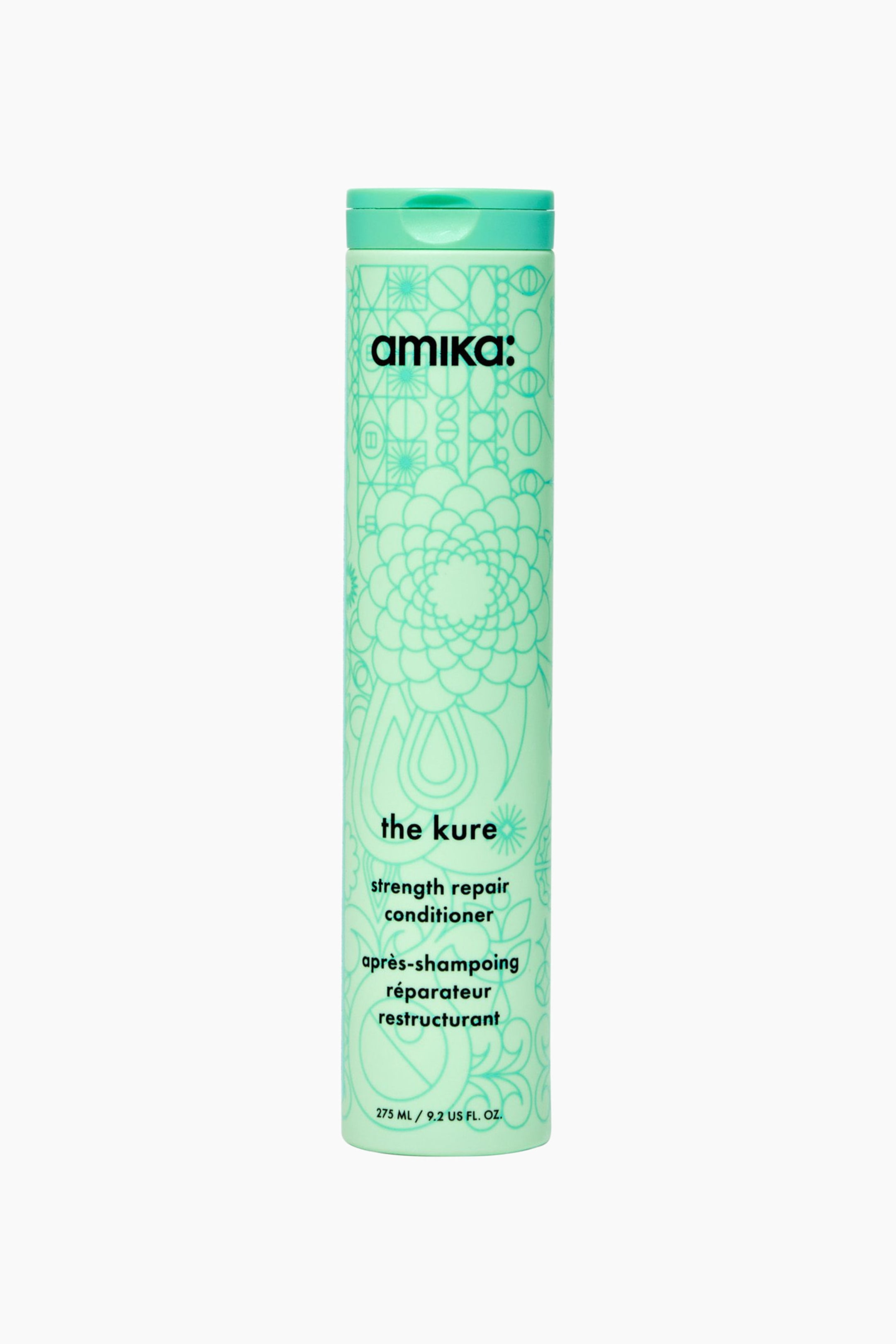 Visa större bild: En cylindrisk mintgrön flaska med amika: the kure strength repair conditioner står upprätt i en rakt framifrånvy. Flaskan har ett intrikat, ton-i-ton-blommigt och geometriskt mönster, ett matchande flip-top-lock och svart text som visar varumärket och produktinformationen.