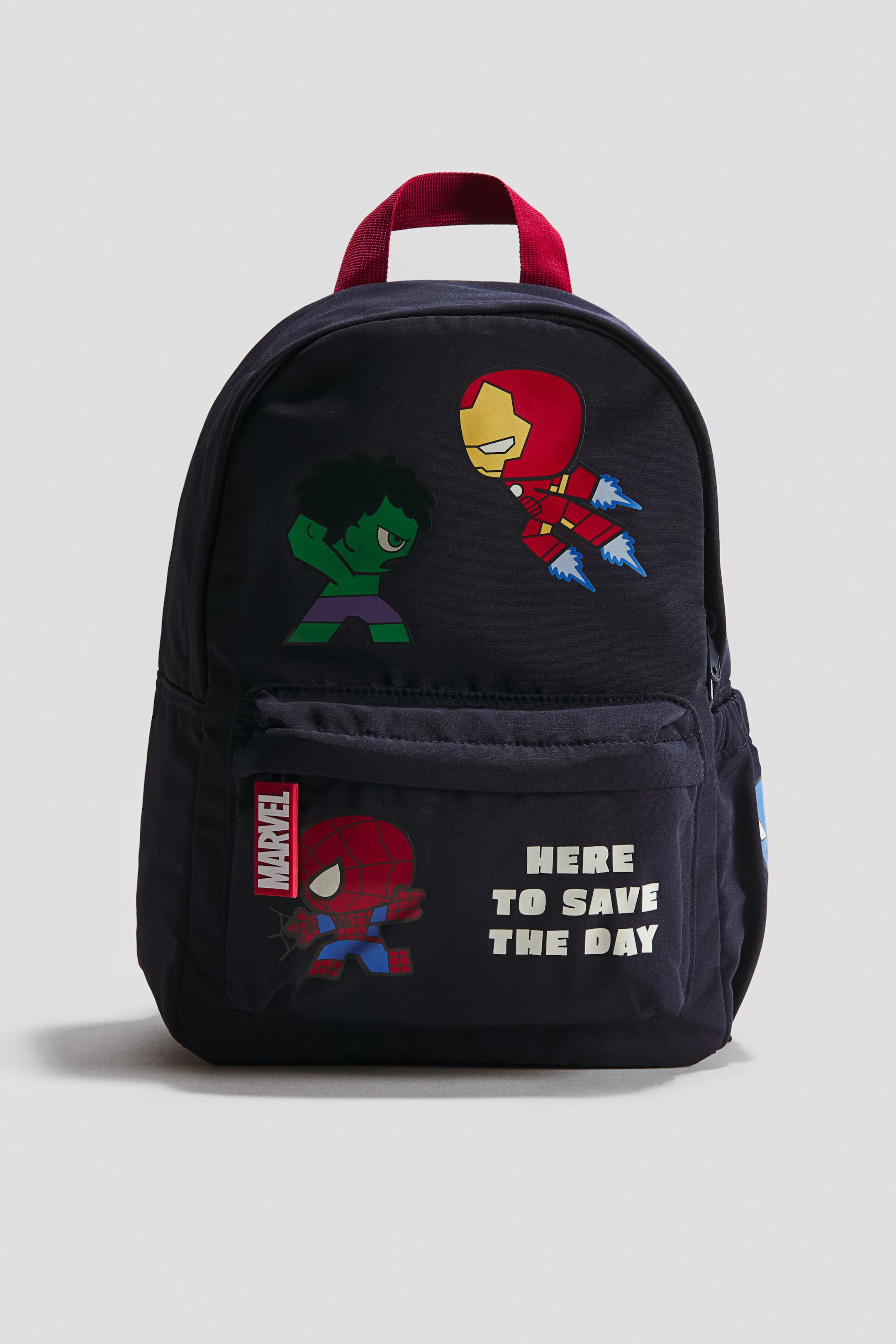 Visa större bild: En marinblå ryggsäck vänd framåt, med ett rött topphandtag och ett rundat huvudfack som visar chibi-stil grafik av Hulk och Iron Man. En främre ficka visar en chibi Spider-Man grafik, en 'Marvel' tagg och texten 'HERE TO SAVE THE DAY', med en sidonätficka delvis synlig på höger sida.