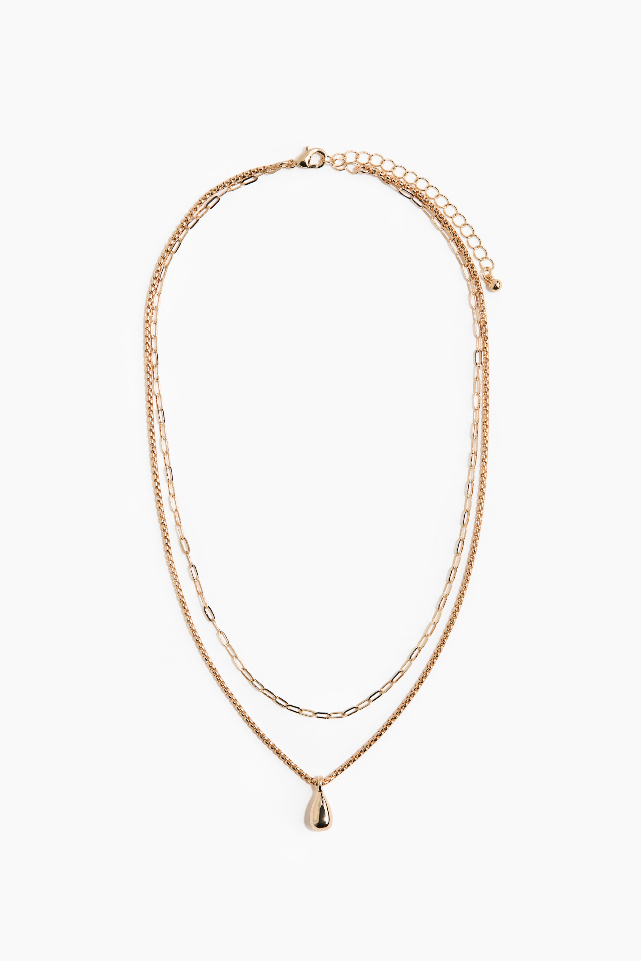 View larger image: A gold-toned layered necklace is featuring two distinct chains. The upper chain is an elongated oval link style, and the lower chain is a tighter box-like link style with a smooth, teardrop-shaped pendant. A lobster clasp and extender chain are visible at the top.