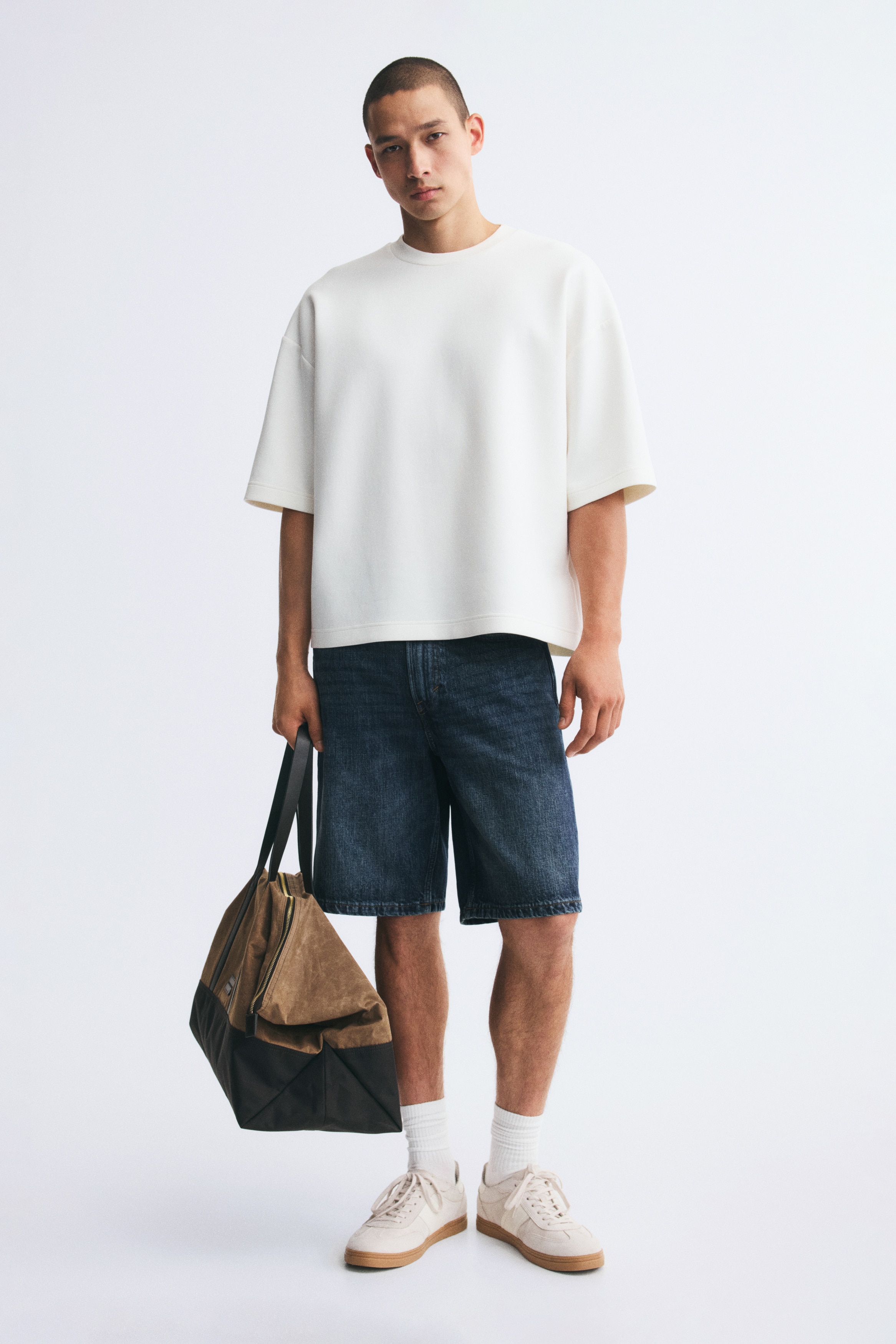 Die dunkelblauen Jeansshorts präsentieren sich mit einer verwaschenen Optik und kontrastierenden Nähten. Sie verfügen über einen vorderen Knopf- und Reissverschluss, Gürtelschlaufen sowie Vordertaschen mit einer zusätzlichen Münztasche.