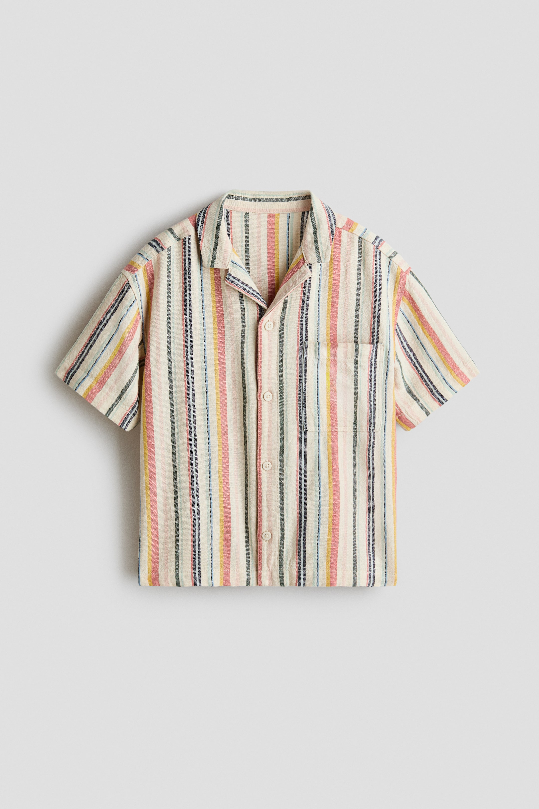 View larger image: A short-sleeved shirt is presented front-facing, featuring vertical multi-coloured stripes in pink, yellow, blue and green on a cream base. It is designed with a revere collar, a button-front closure and a single patch pocket on the left chest.