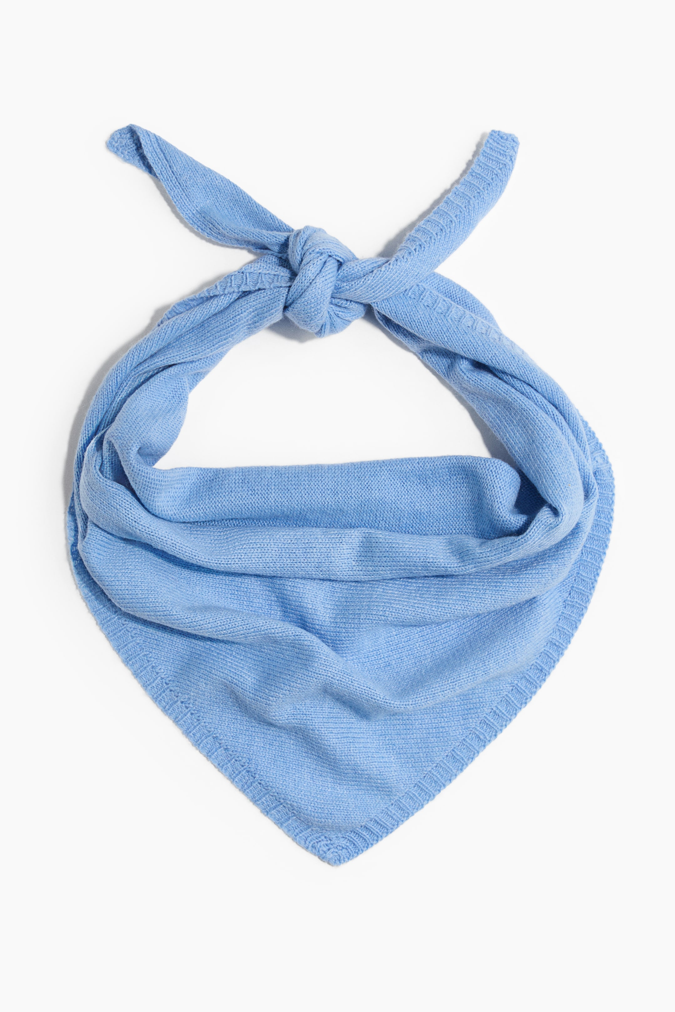 View larger image: A light blue triangular scarf in a soft, fine knit is shown from the front, tied in a knot at the top. The fabric drapes downward in soft folds to form a pointed shape, showcasing its ribbed borders.