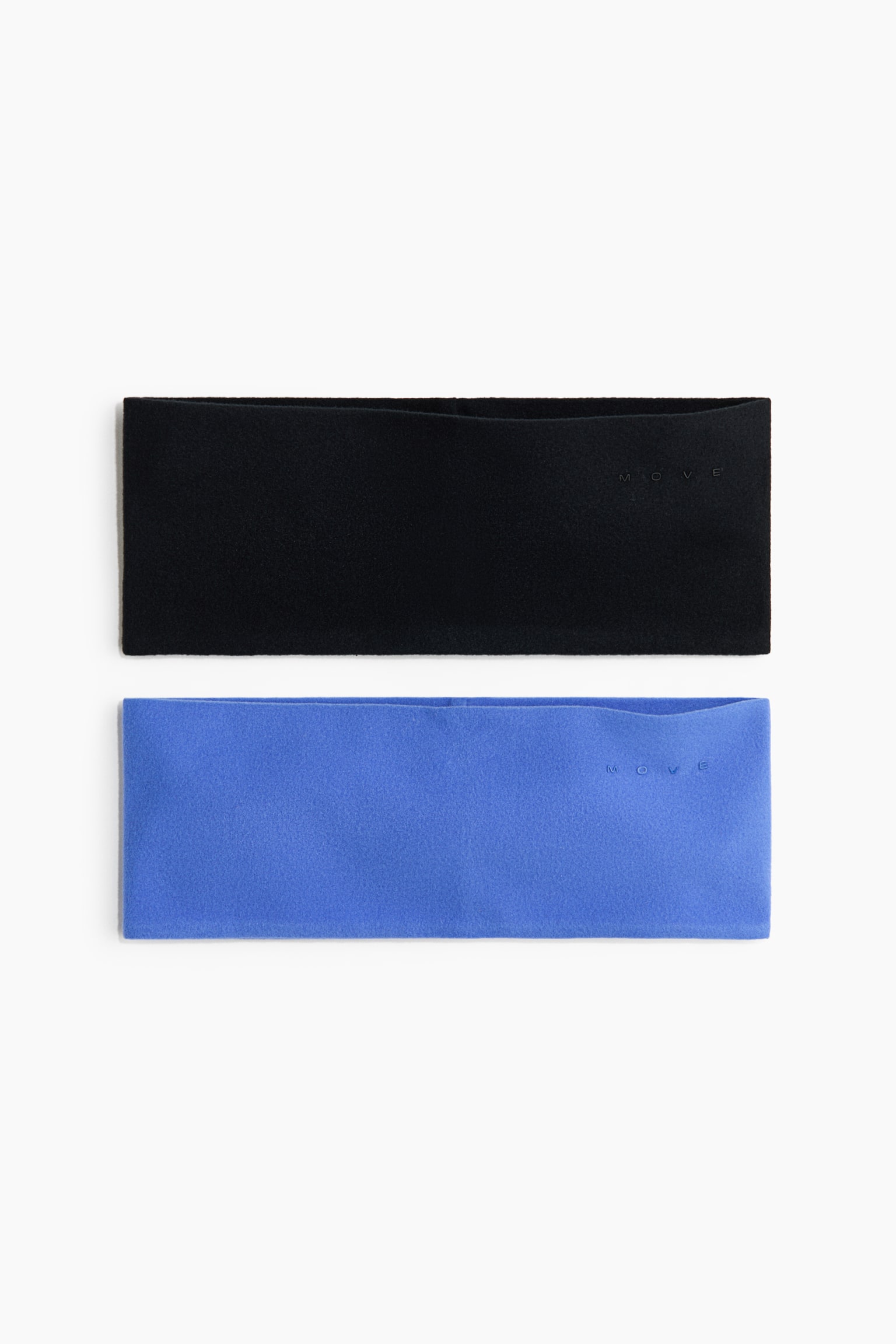 Dos diademas anchas de forro polar, una negra y una azul, estÃ¡n colocadas en plano en una vista frontal. Cada diadema presenta un borde superior contorneado y un pequeÃ±o logotipo "MOVE" sutilmente en relieve en el lado derecho.