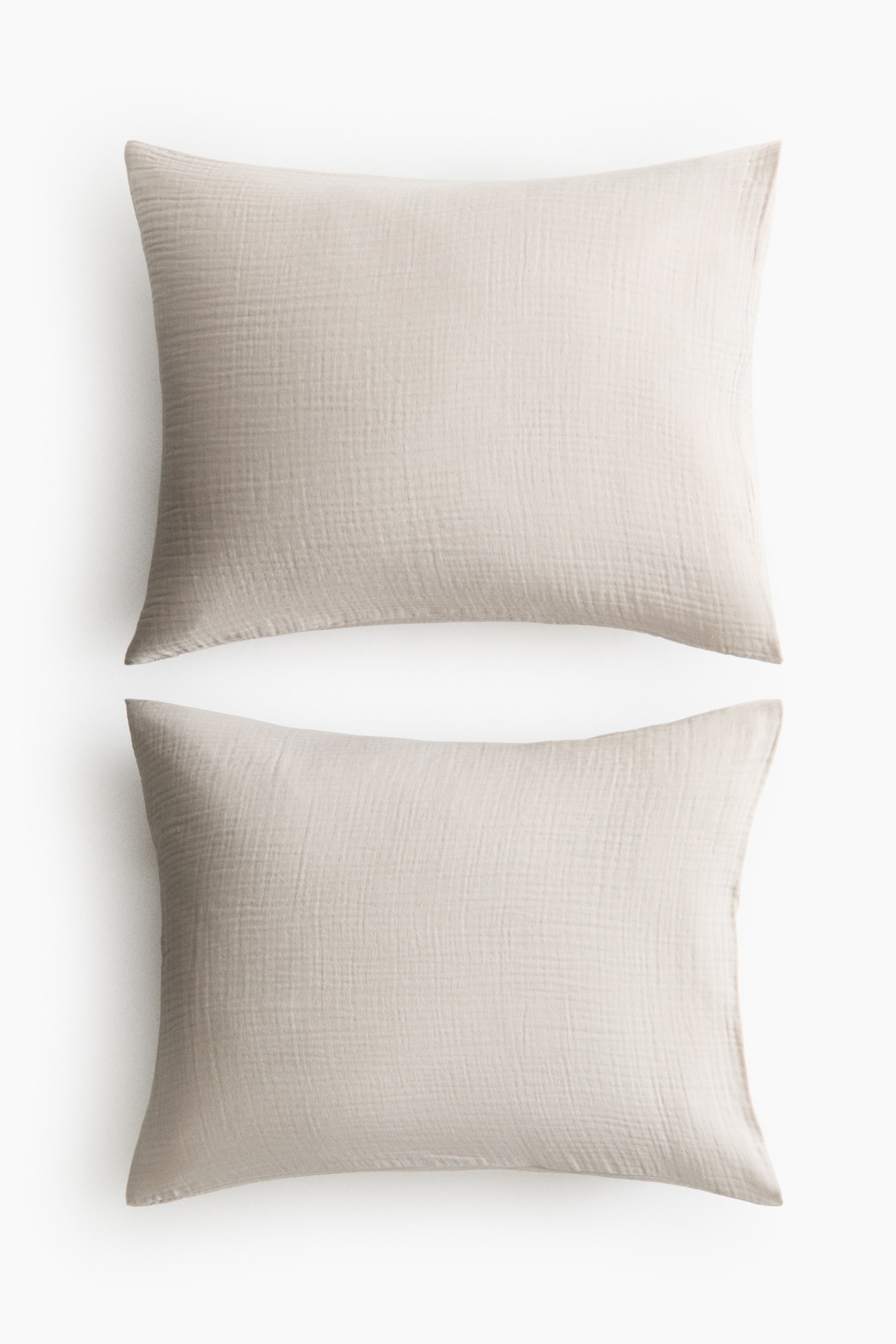 View larger image: Two light beige rectangular pillowcases exhibit a crinkled, gauze-like texture and are positioned front-facing, one atop the other.
