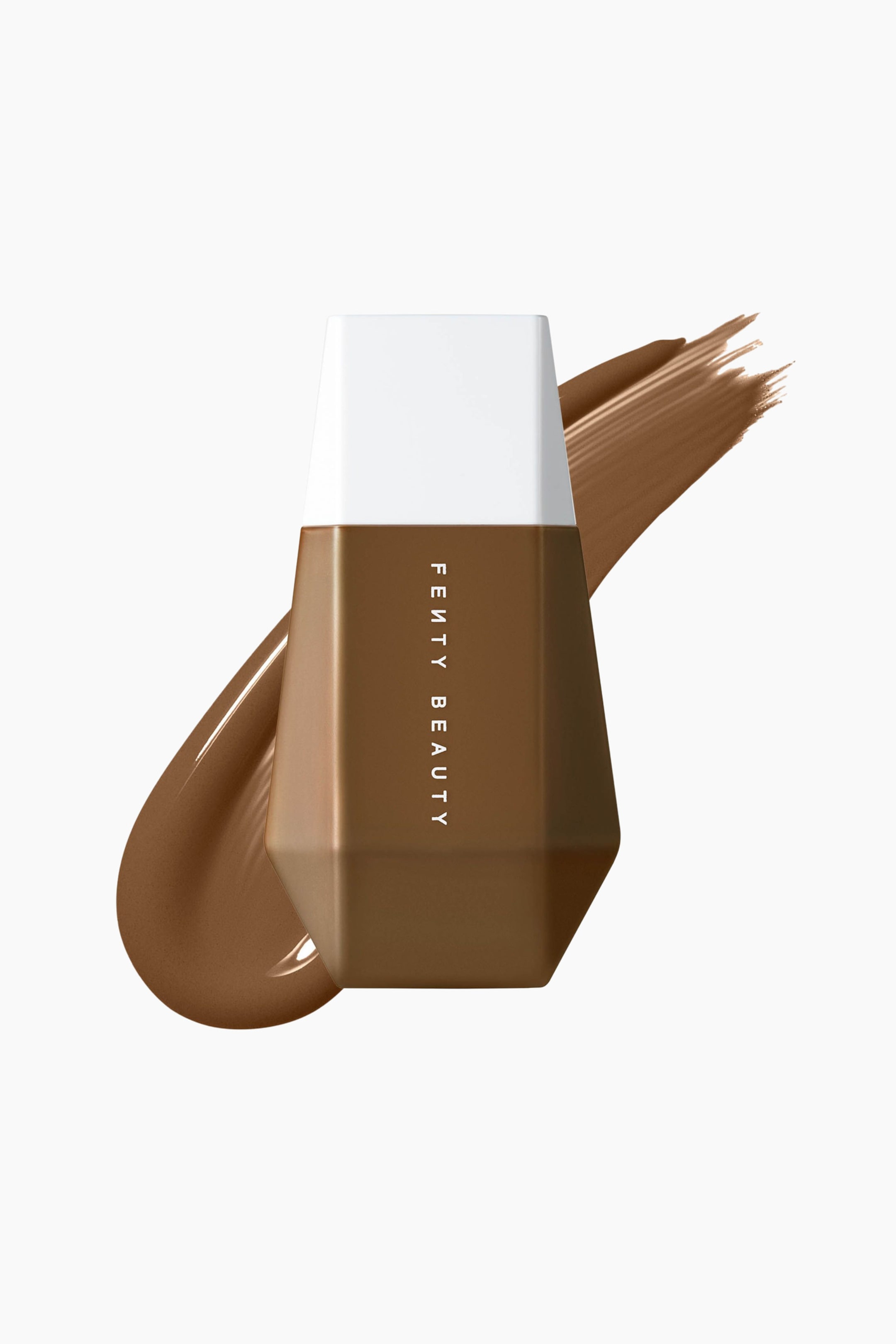 Visa större bild: En geometrisk, facetterad flaska med Fenty Beauty Eaze Drop skin tint står upprätt i frontalt vy, med vit kork och mörkbrun kropp med lodrät vit text. Ett tjockt diagonalt svep av den matchande mörkbruna flytande formulan sveper bakom flaskan och framhäver dess lena textur.