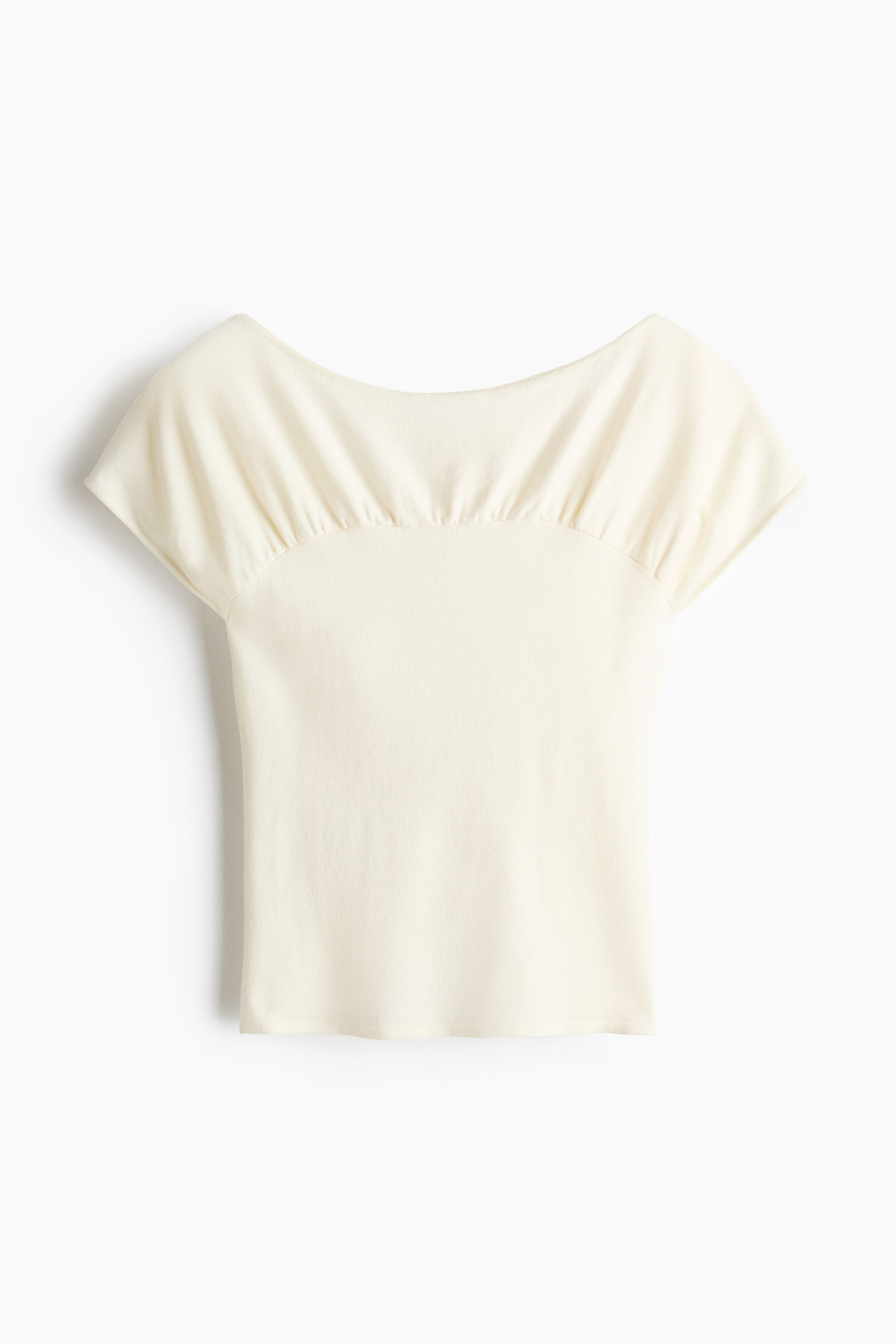 View larger image: A cream-coloured top showcases its front, boasting a boat neckline with ruching across the upper bodice and short cap sleeves.
