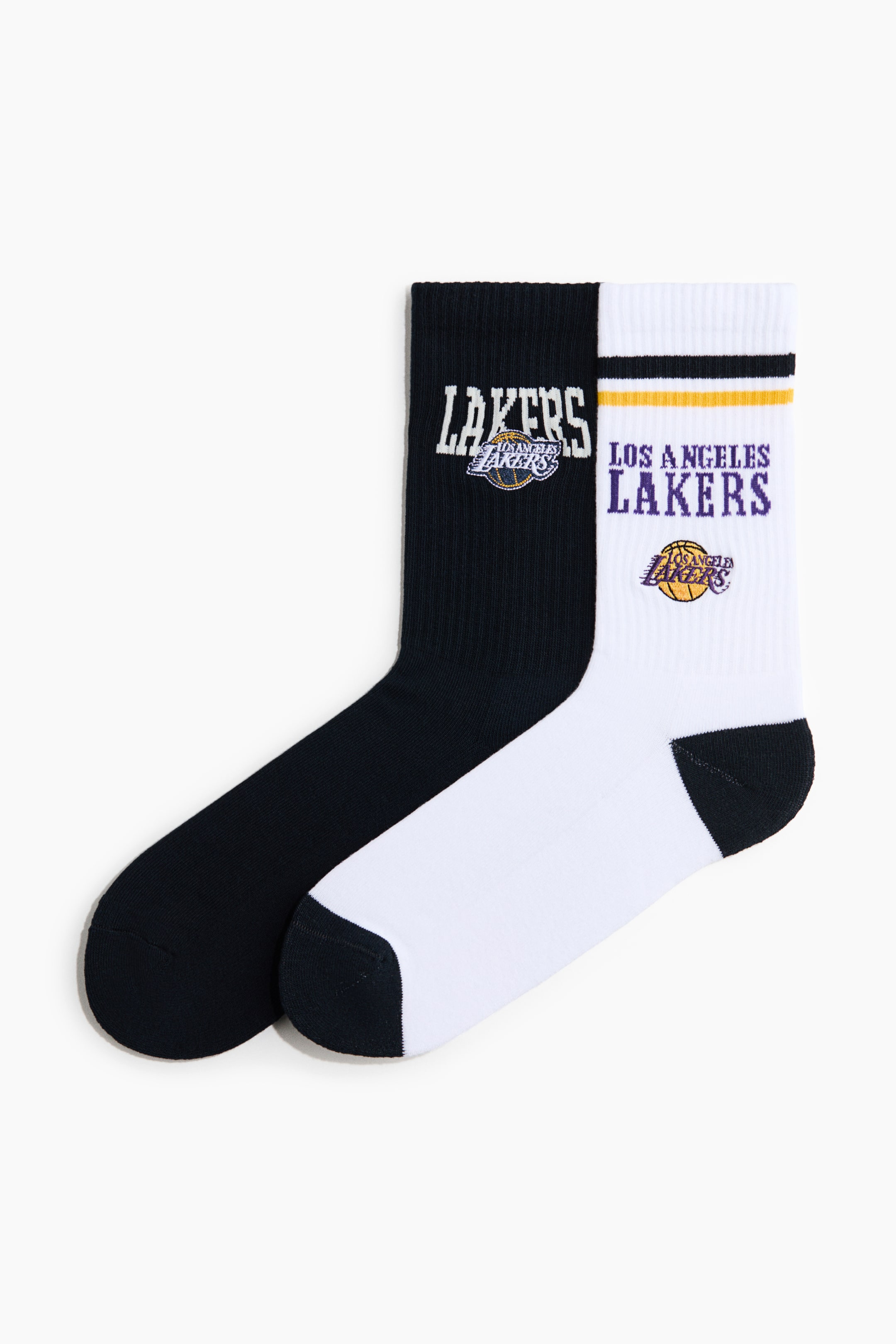 Visualizza l'immagine ingrandita: Un paio di calze a maglia fine presenta la parte anteriore, caratterizzate da gambali alti e a coste. La calza nera mostra la scritta "LAKERS" in bianco con il logo dei Los Angeles Lakers, mentre la calza bianca presenta la scritta "LOS ANGELES LAKERS" in viola con il logo dei Los Angeles Lakers e strisce nere e gialle.