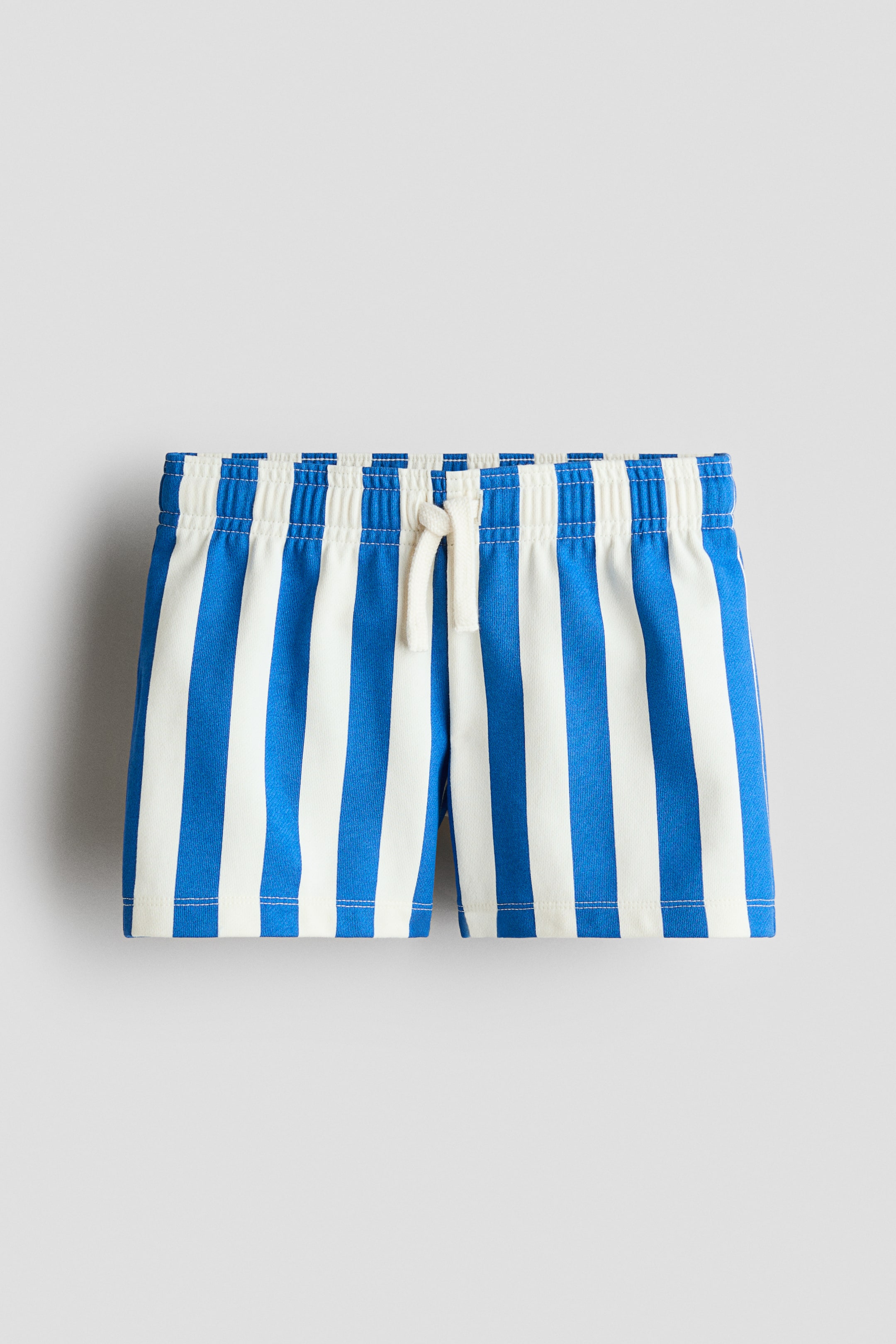 View larger image: Loose-fit shorts showcase blue and off-white vertical stripes. Crafted from lightweight cotton sweatshirt fabric, they feature an elasticated drawstring waist visible from the front.