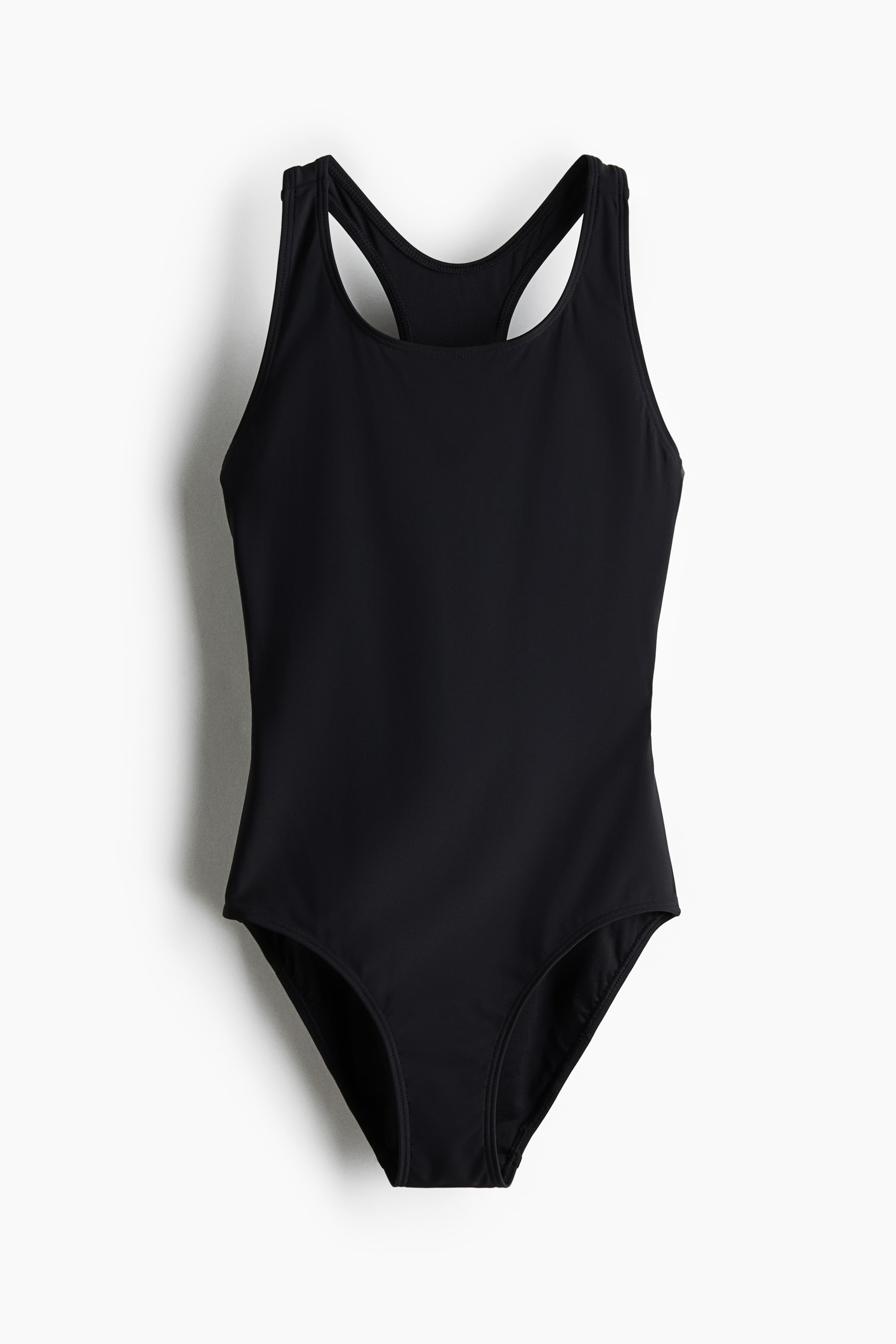 View larger image: A black one-piece swimsuit is shown from the front, highlighting a shallow scoop neckline and wide straps that meet at the upper back in a racerback design. Crafted from a smooth, matte fabric, it features a moderate leg cut.