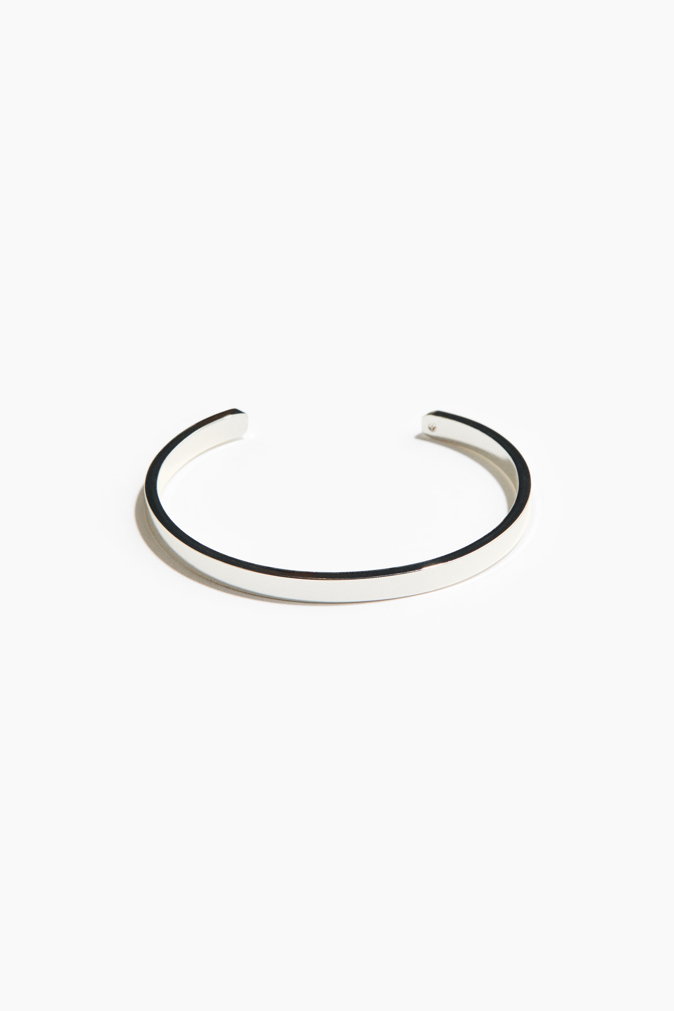 Agrandir l'image: Un bracelet manchette en argent présente son design ouvert en forme de C, avec une surface supérieure polie et réfléchissante et des bords plats et finis.