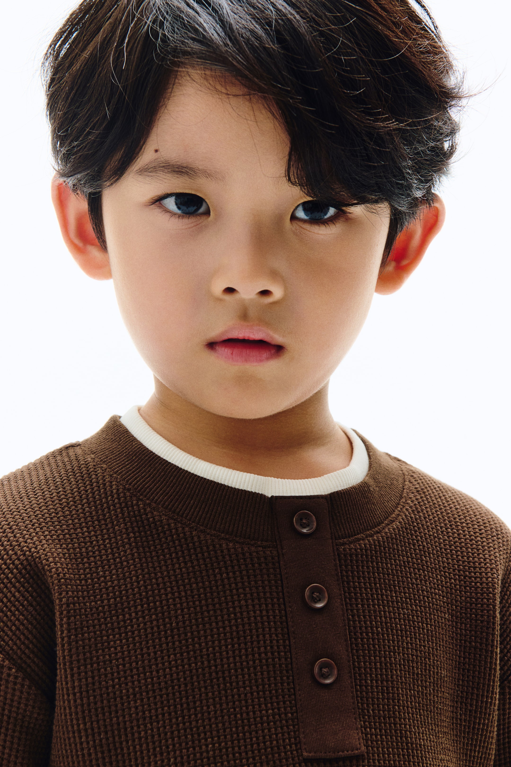 View larger image: A brown waffle-knit henley shirt is being presented, featuring a ribbed collar and a three-button placket. 