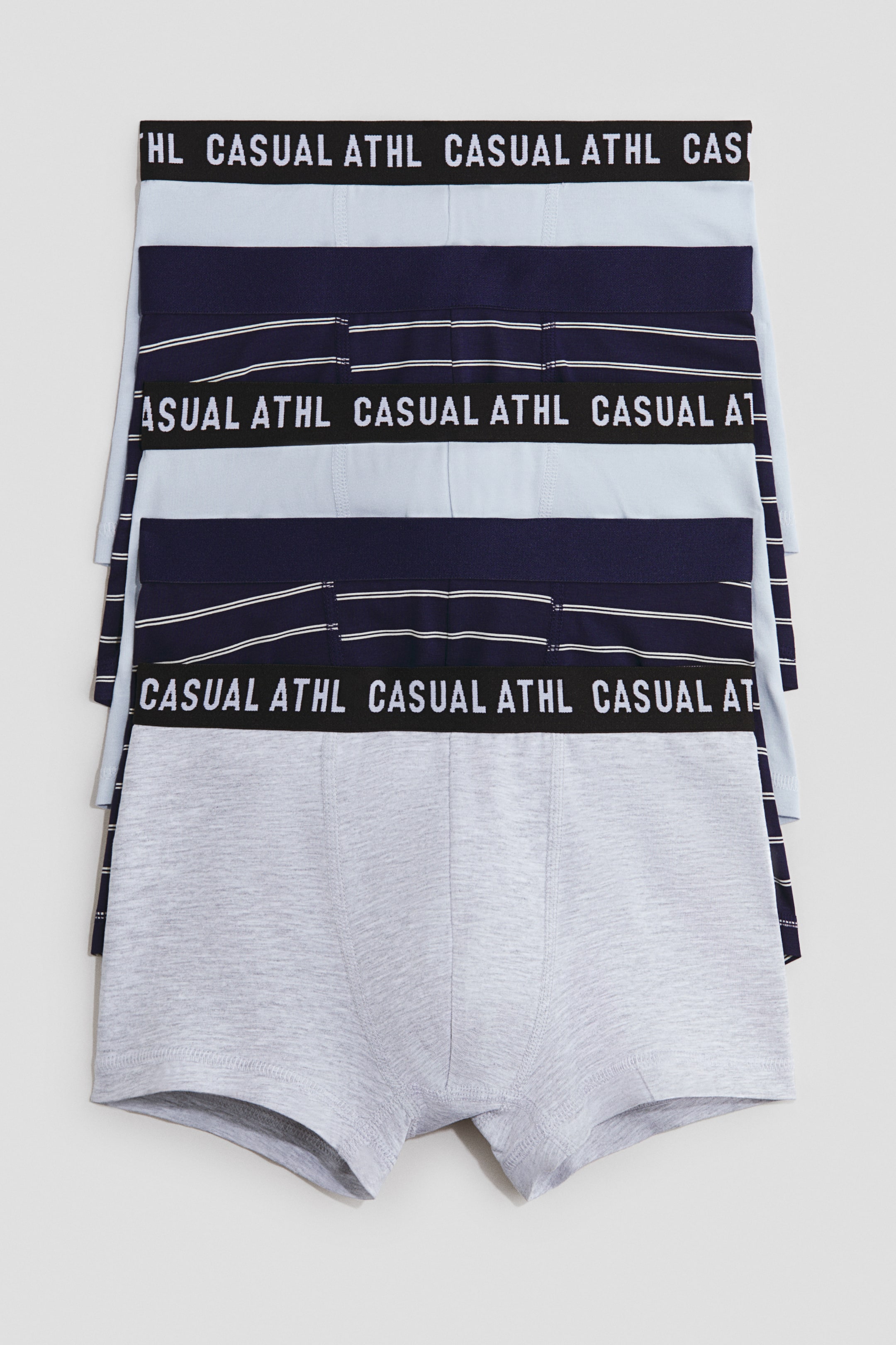 Ver imagen más grande: Calzoncillos de jersey de algodón con perneras cortas, cintura elástica y parte delantera forrada se presentan como un conjunto de cinco pares, todos mirando hacia adelante. El conjunto muestra un patrón repetido de azul claro, azul oscuro con finas rayas blancas, azul claro, azul oscuro con finas rayas blancas, y un par sólido de gris claro en la parte inferior. Las cinturas elásticas exhiben el texto 'CASUAL ATHL', y el par gris inferior muestra claramente su construcción forrada en la parte delantera.