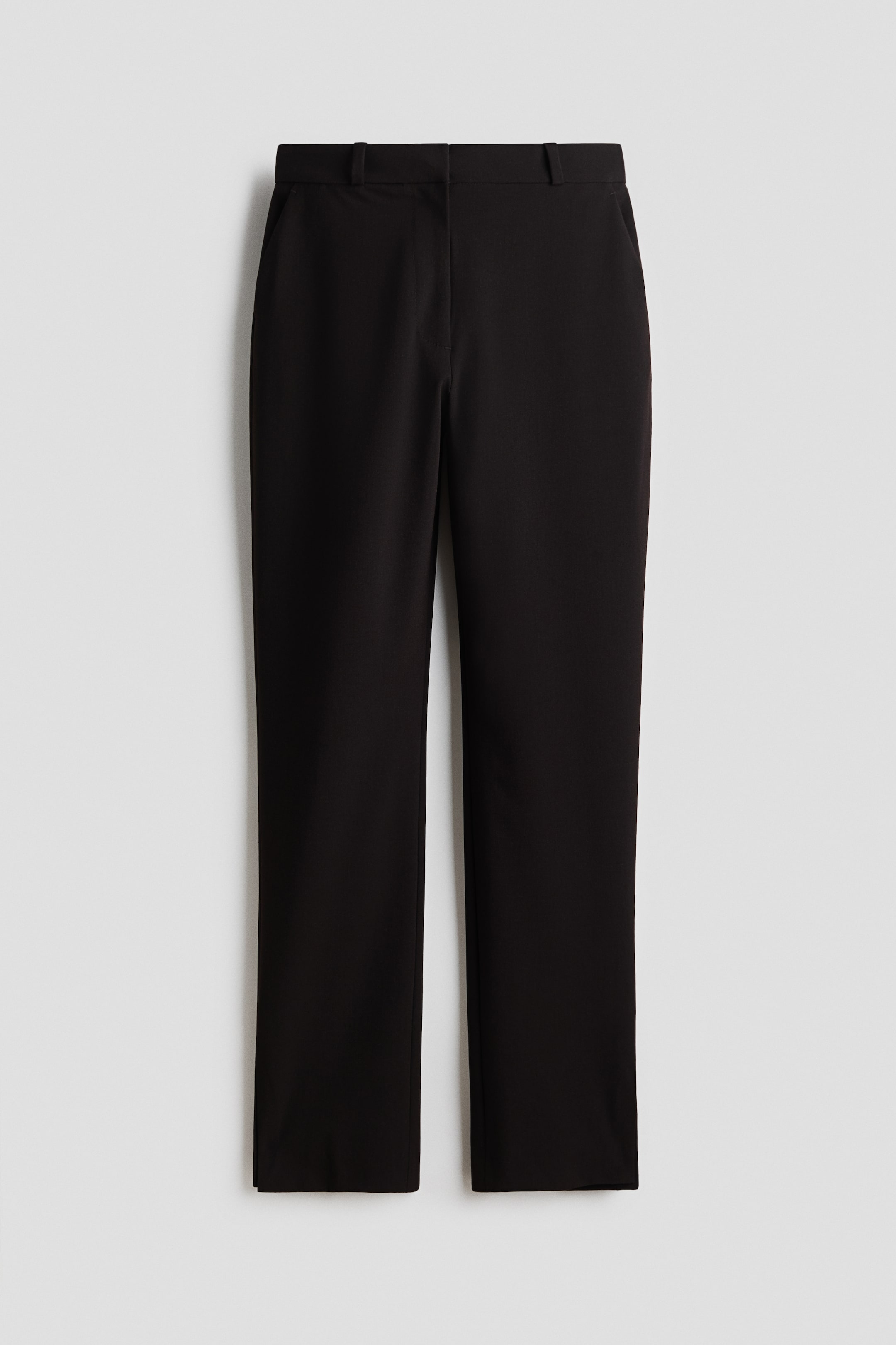 View larger image: The black, wrinkle-resistant, slim-fit tailored trousers are shown from the front, featuring a flat waistband with belt loops and subtle side pockets. Their slim, straight legs present a tailored appearance with slight front creases.