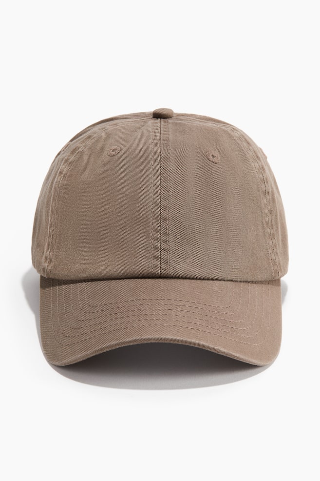 A brown cotton twill cap is showcased from the front, featuring a six-panel crown with a top button and ventilation eyelets, along with a curved brim displaying multiple rows of stitching. - 1
