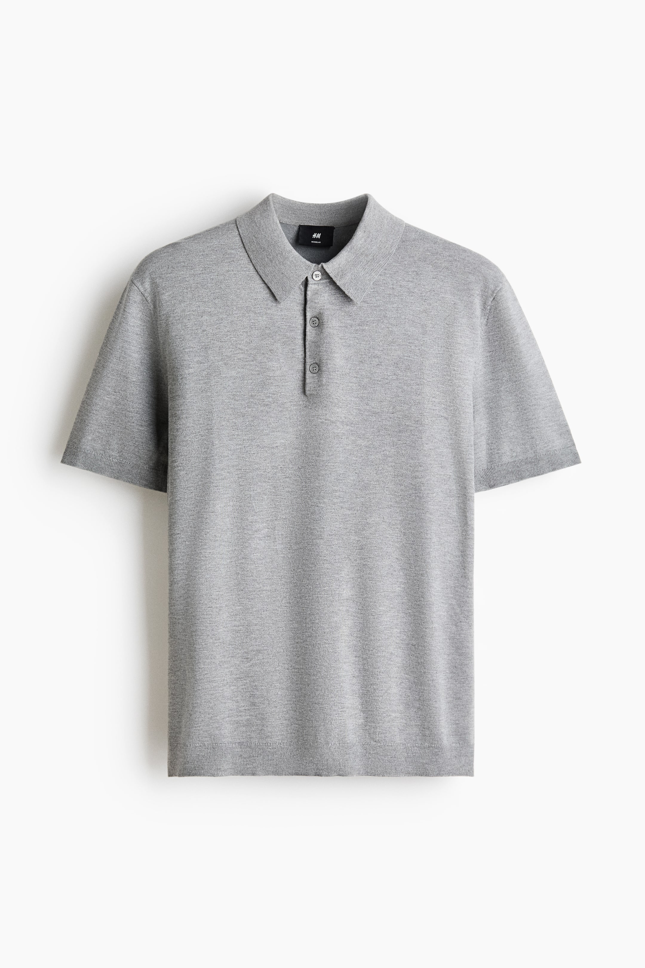 Grotere afbeelding bekijken: Een grijze gebreide poloshirt met een puntige kraag en een drieknoopssluiting met grijze knopen. Het is ontworpen met korte mouwen en geribde manchetten, samen met een geribde zoom.