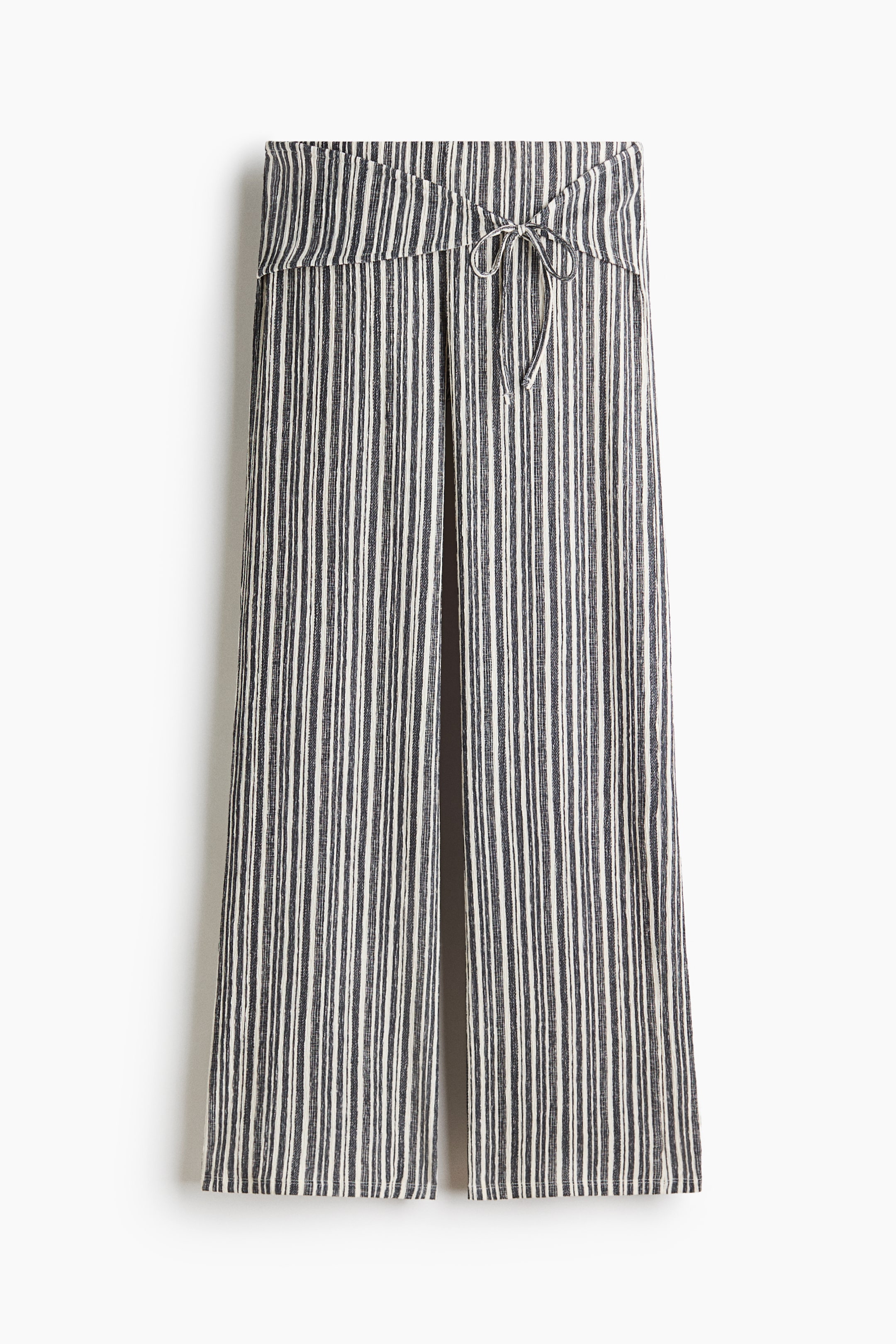 View larger image: Trousers in textured jersey feature vertical dark and light stripes, showcasing a low waist with a wide, belt-look panel that ties at the front, and are designed with straight legs.