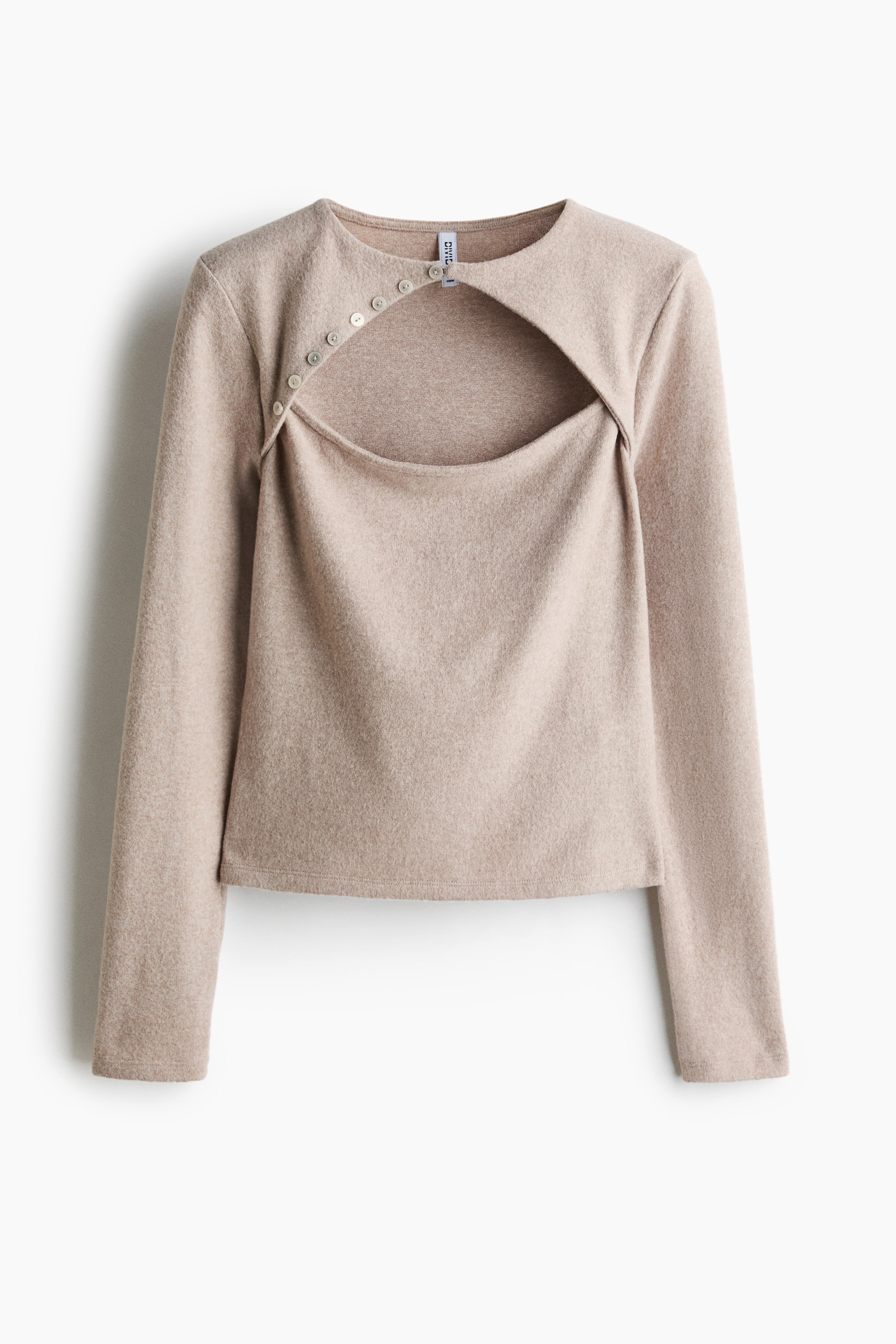 Voir une image plus grande: Un haut en tricot beige à manches longues est présenté de face, avec un col rond et une grande ouverture asymétrique à la poitrine. Une ligne diagonale de petits boutons de couleur claire s’étend du col jusqu’au côté de l’ouverture.