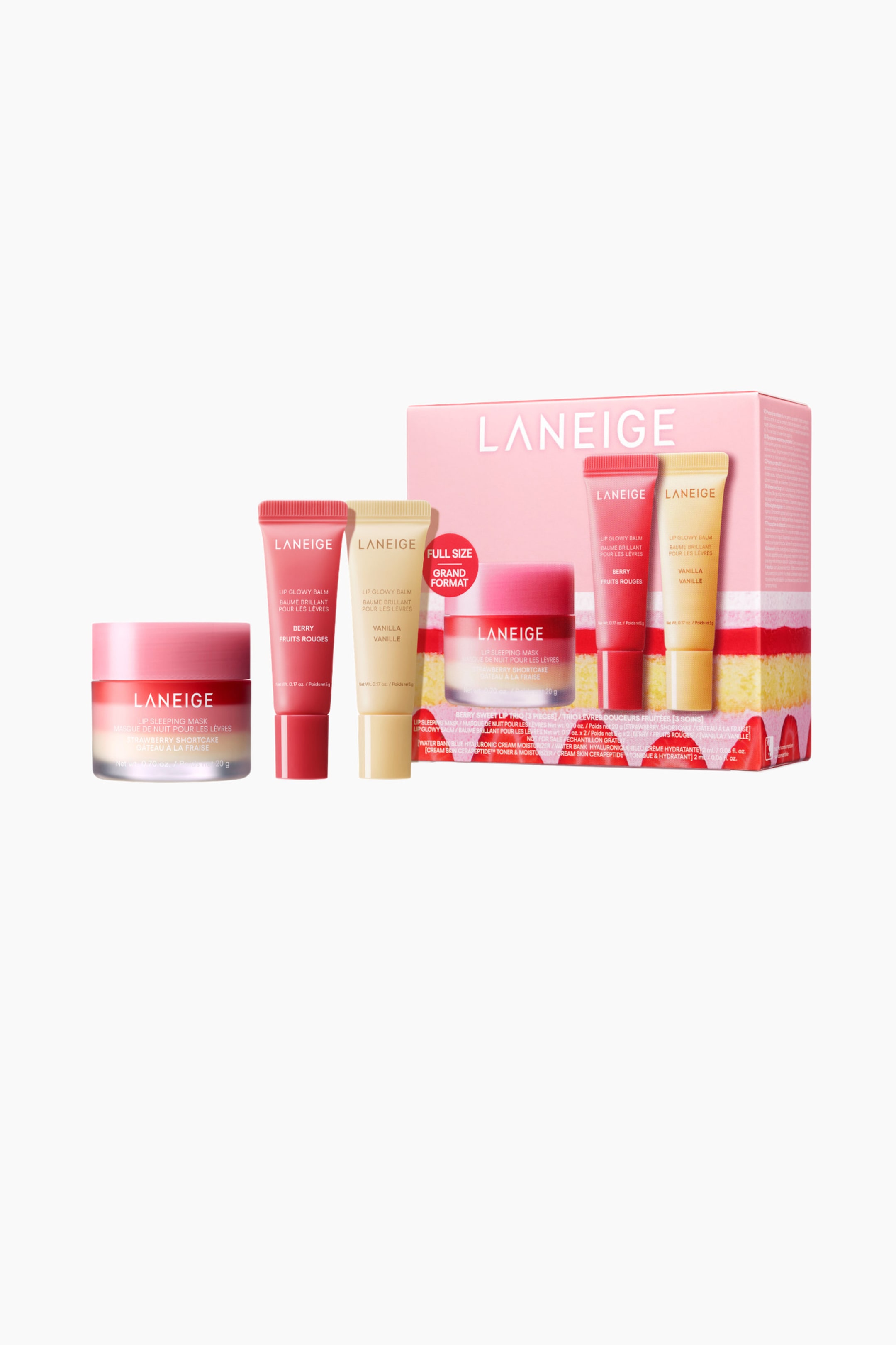 Visa större bild: Ett LANEIGE läppvårdssätt presenterar en stor gradient rosa och klar burk med Strawberry Shortcake läpp sovmask och två stående tuber med läpp glowy balm i Berry och Vanilla. En rosa presentask, dekorerad med en lagerkaka design på sin nedre halva, är placerad till höger, och visar en mindre burk med läpp sovmask och två läpp glowy balm tuber, varav en indikerar "FULL SIZE."
