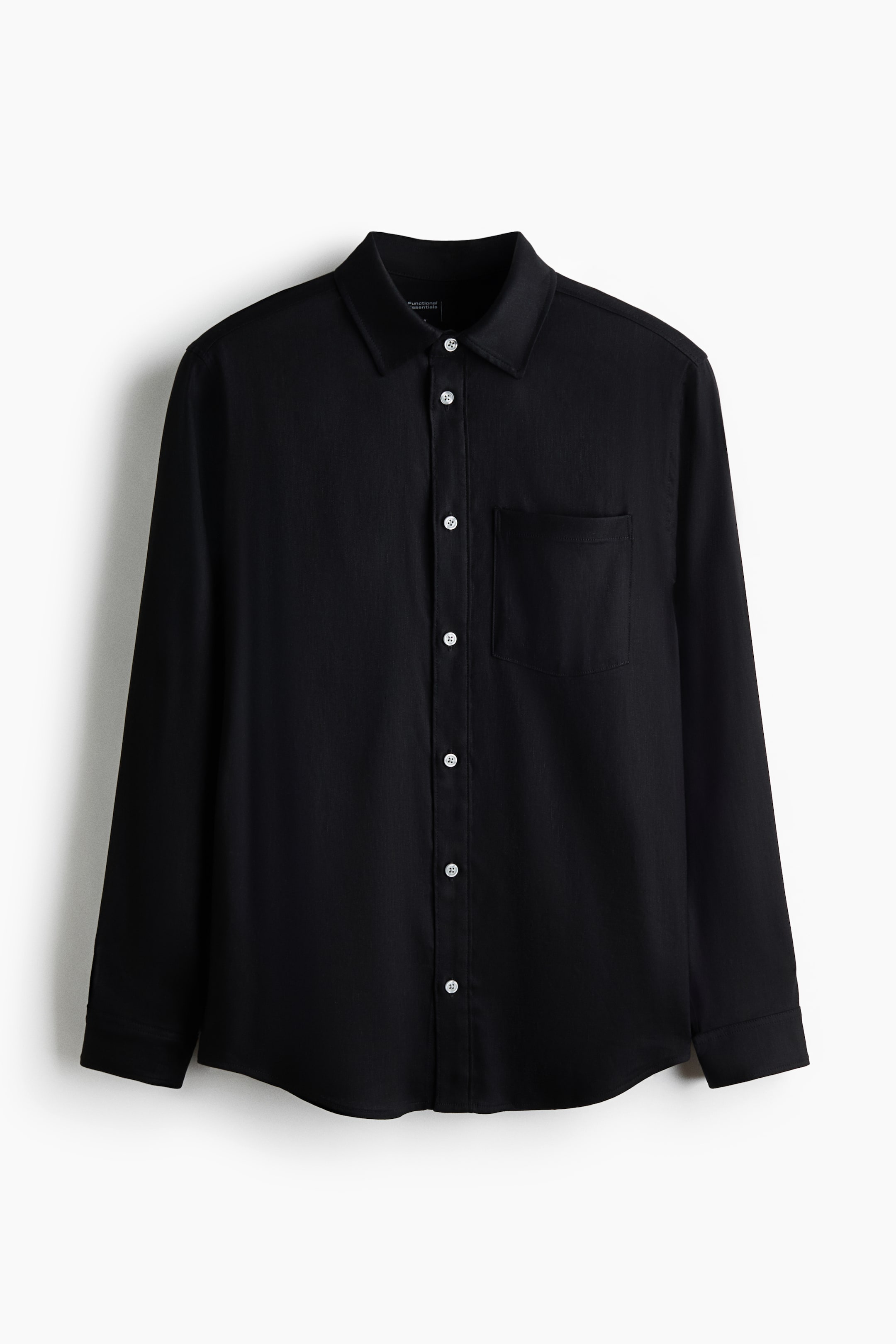 View larger image: A black shirt, crafted from a stretchy moisture-wicking linen-blend weave, is displayed front-facing. It features a turn-down collar, a button-down front with white buttons, a patch chest pocket on the left, long sleeves with adjustable buttoned cuffs, and a rounded hem.