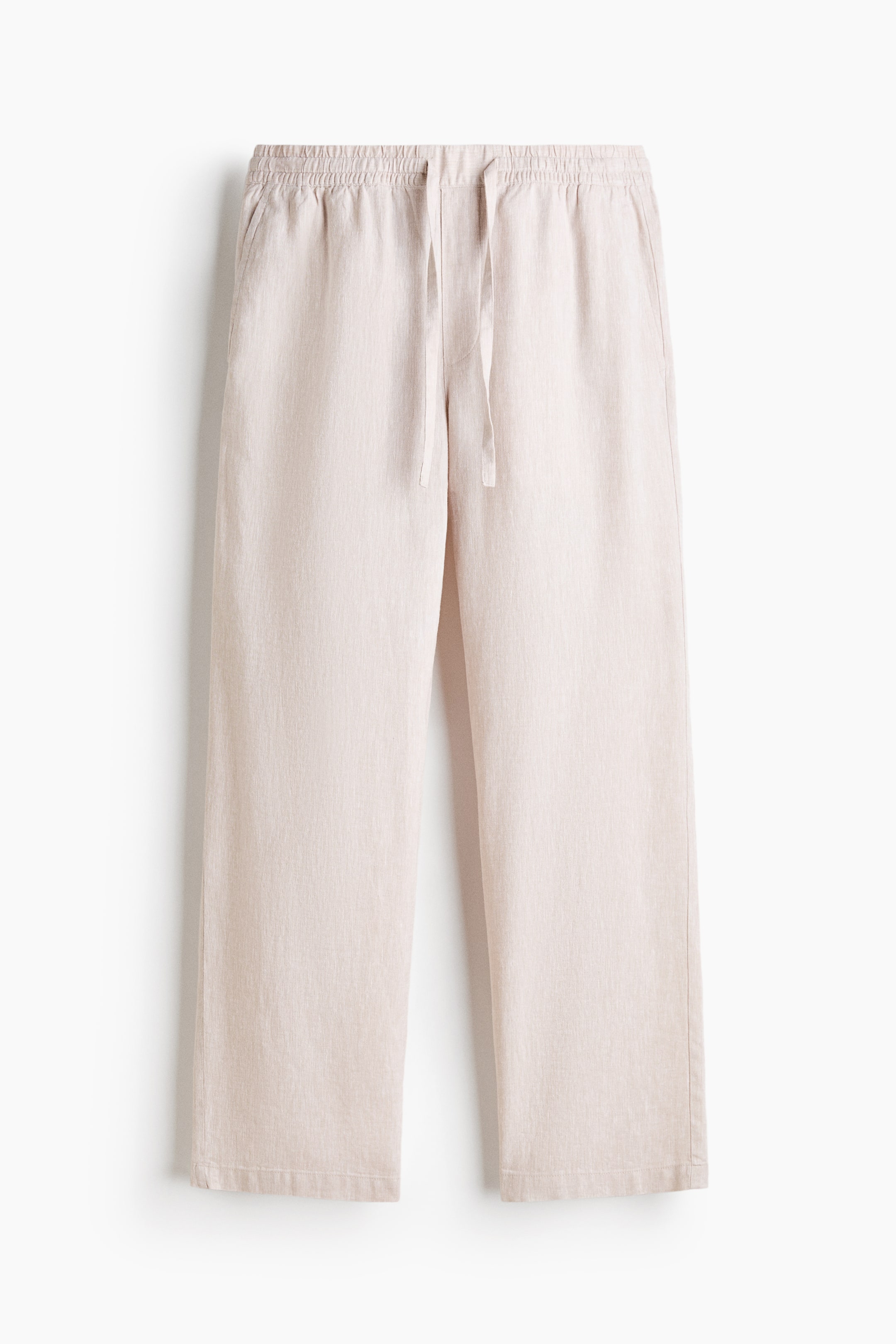 View larger image: These light beige trousers are hung in a front view, showcasing a relaxed, straight-leg cut in a textured linen-like fabric. The design features an elasticized waistband with an adjustable drawstring and discreet side seam pockets.