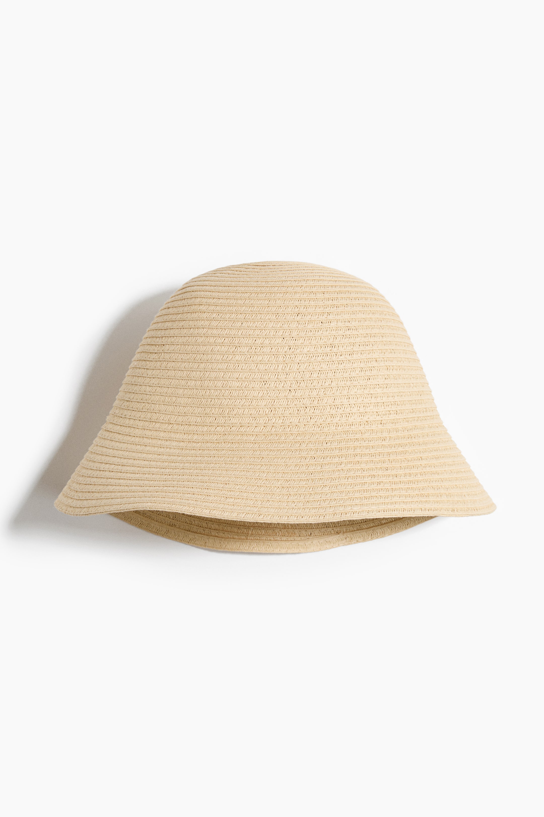 Ampliar la imagen: Un sombrero tejido de color beige claro está orientado hacia el frente, con una corona redondeada, un ala inclinada hacia abajo y una textura tejida horizontalmente en toda su superficie.