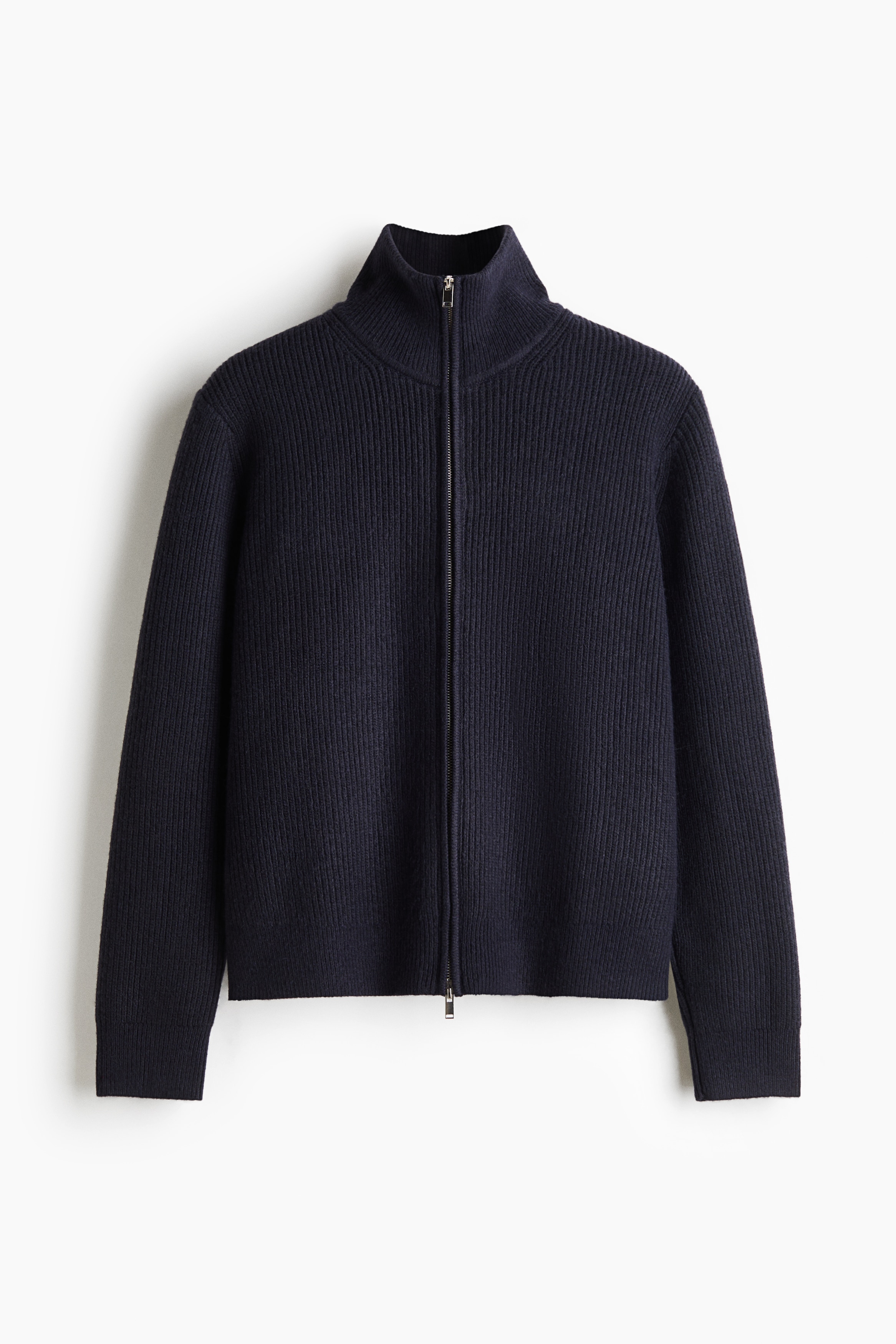 A dark rib-knit cardigan with a stand collar and a two-way front zip is being worn by the model. The regular-fit cardigan is layered over a white T-shirt and paired with dark, wide-leg trousers.