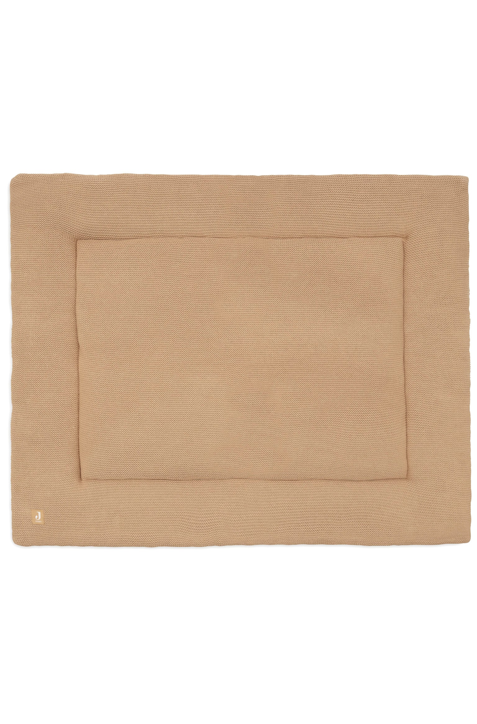 Een rechthoekige gebreide mat in een warme beige kleur ligt plat, met een gewatteerd middengedeelte omringd door een brede, gestructureerde gebreide rand. Aan de linkeronderhoek van de rand is een klein vierkant logolabel bevestigd.