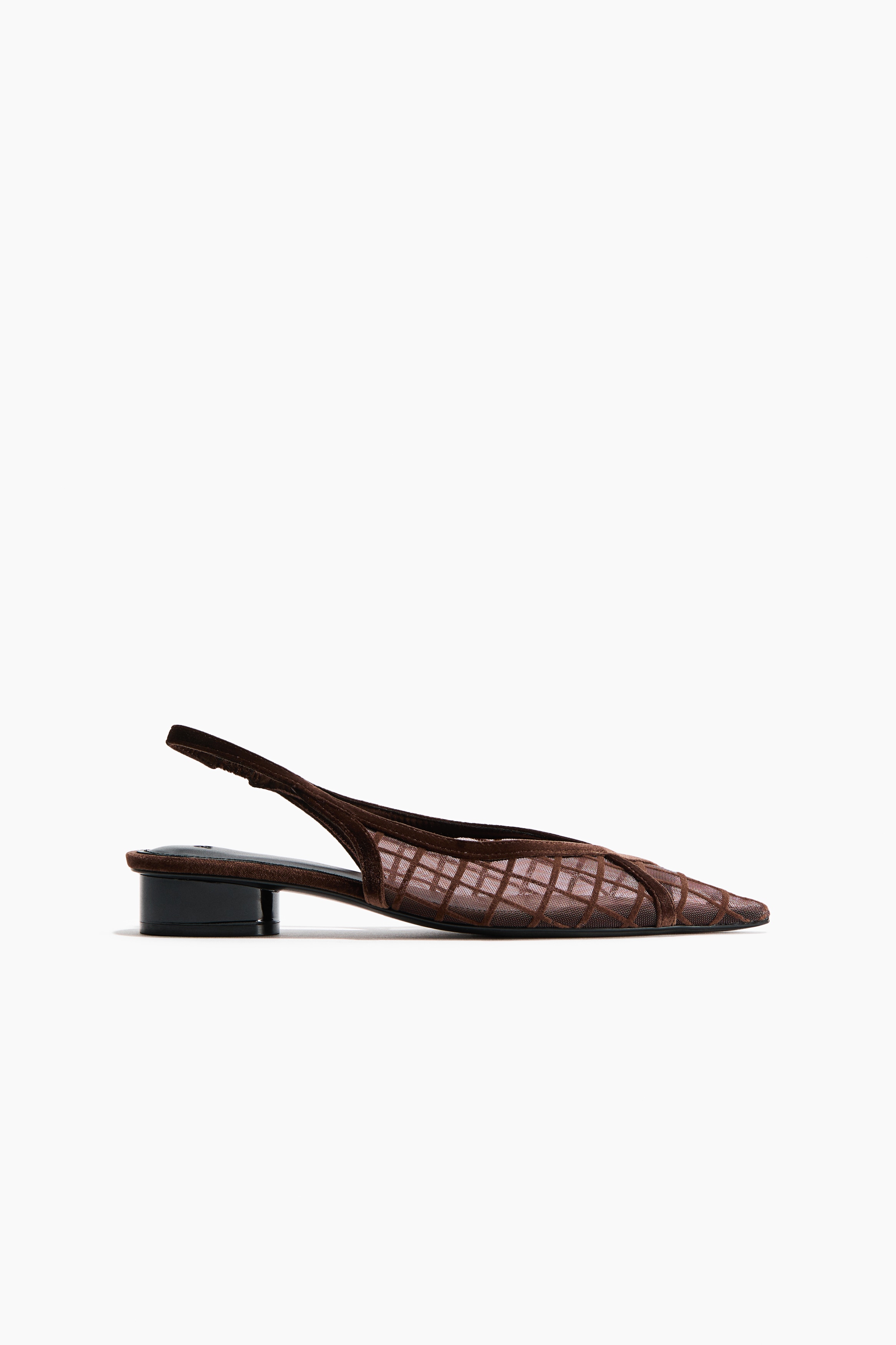 La modelo lleva unos zapatos slingback de tacÃ³n ancho en malla marrÃ³n y terciopelo, con punteras afiladas y tiras decorativas de terciopelo cruzadas, ademÃ¡s de un diseÃ±o de rejilla. Los zapatos se combinan con unos pantalones de efecto piel en marrÃ³n oscuro con bajos abiertos en los tobillos.