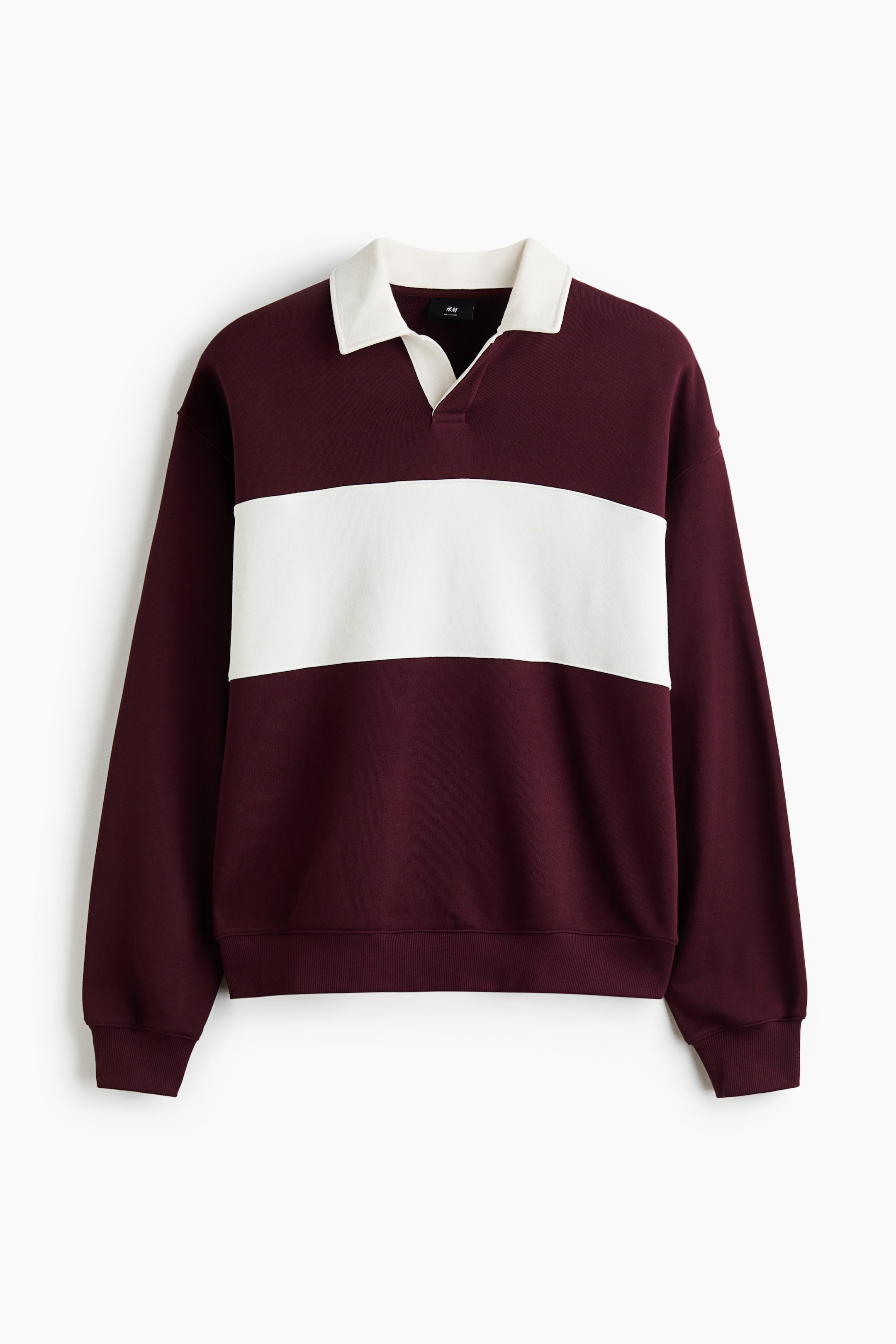 View larger image: This front-facing view is displaying a relaxed-fit burgundy rugby sweatshirt featuring a wide white horizontal stripe across the chest and a contrasting white open collar. The design is showing dropped shoulders, long sleeves, and ribbing at the cuffs and hem.