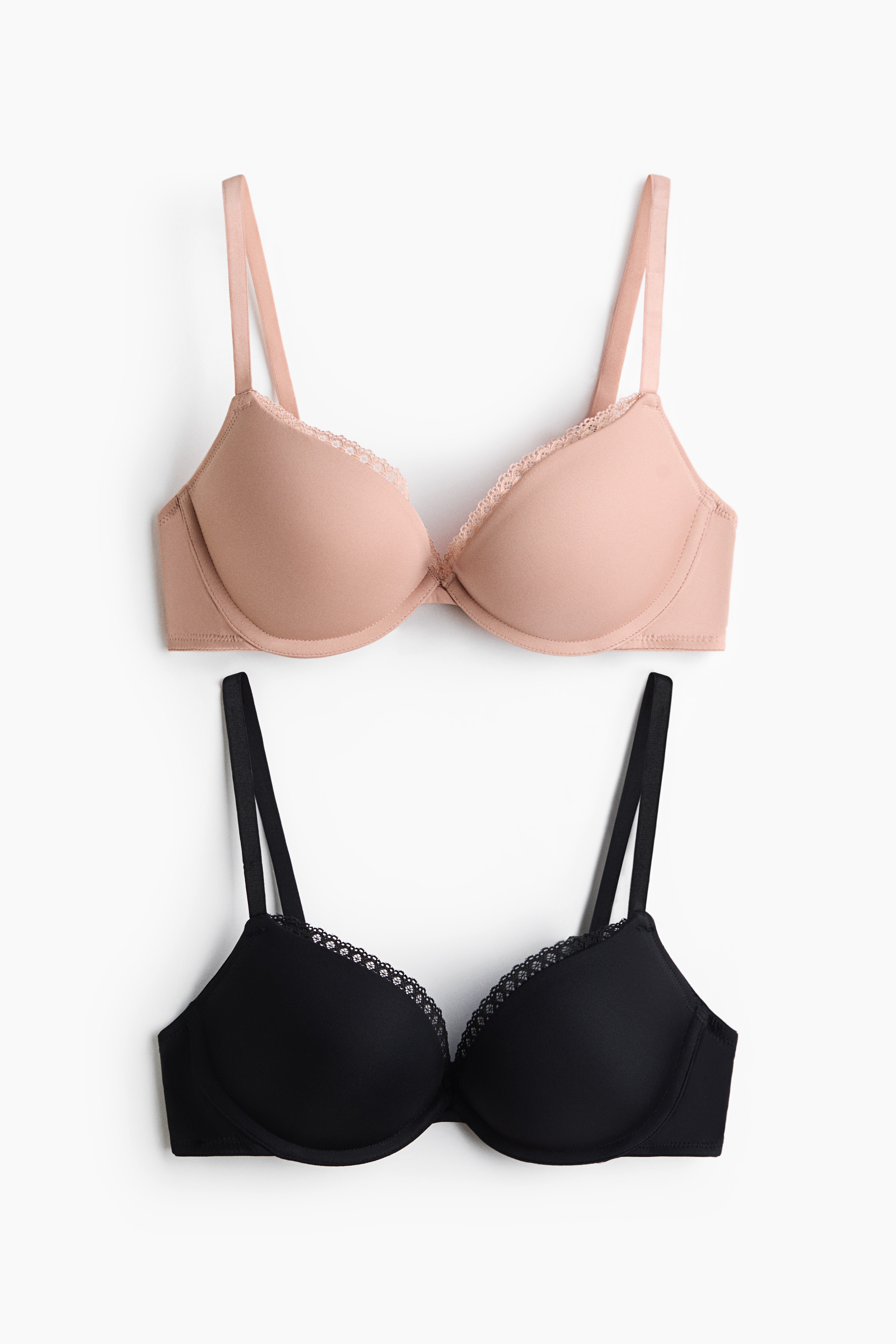 A black push-up bra and matching thong underwear set is featuring thin adjustable straps. The bra is displaying delicate lace trim along the top cup edges, and the thong is showcasing matching lace detail along its waistband.