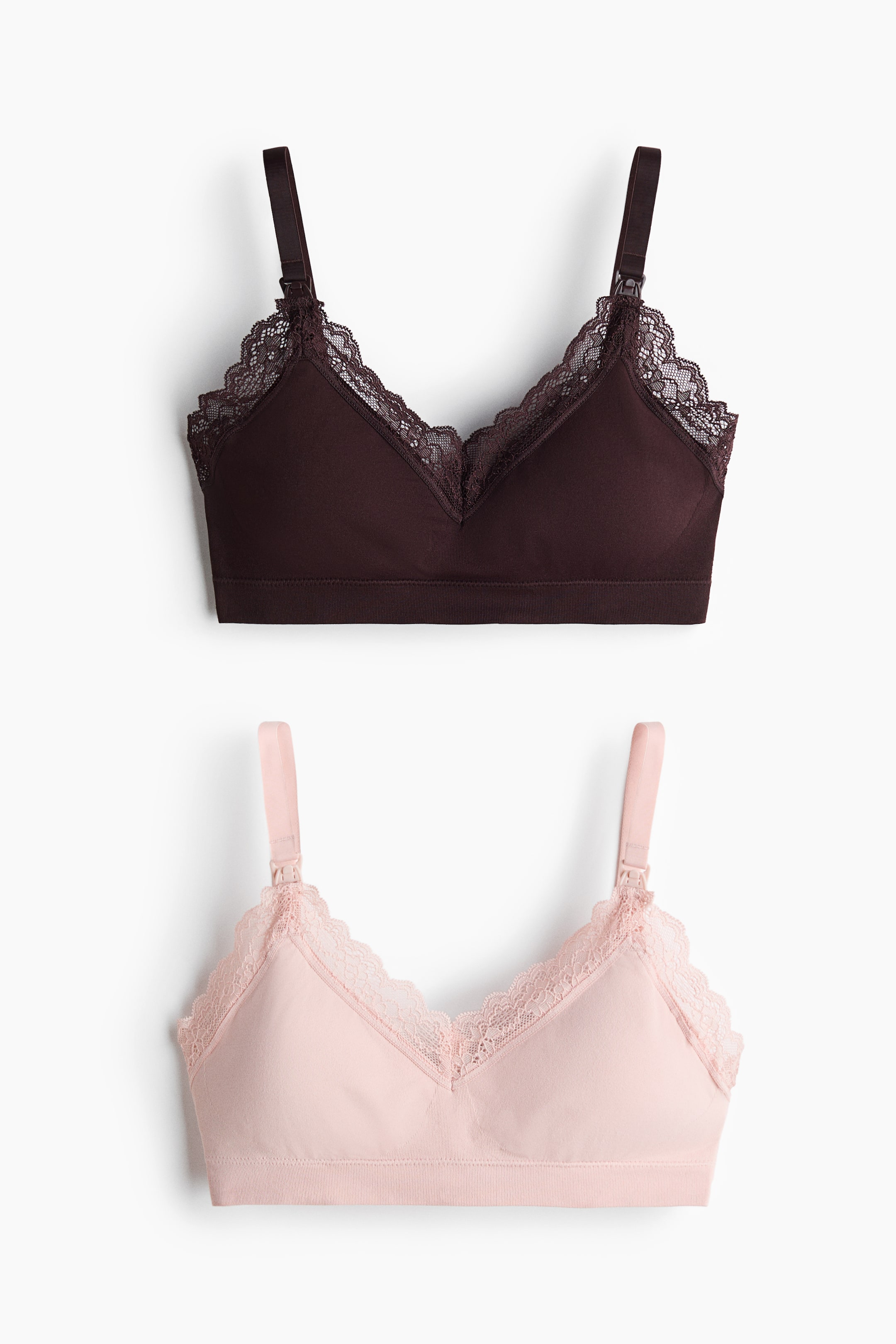 Visualizza immagine più grande: Sono mostrati frontalmente due reggiseni da allattamento in jersey senza ferretto. Il reggiseno superiore è marrone scuro, mentre quello inferiore è rosa chiaro; entrambi presentano un bordo in pizzo lungo i bordi superiori delle coppe foderate e spalline regolabili con clip per allattamento.