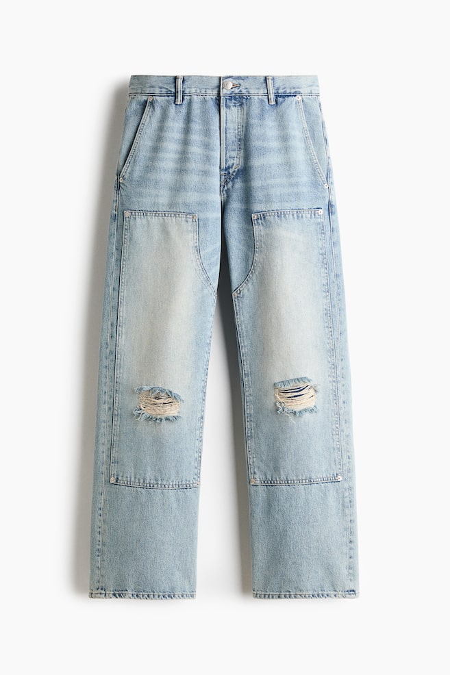 These light-wash blue jeans are shown from the front, displaying a straight-leg silhouette with prominent double-knee reinforcement panels and distressed, frayed rips at the knees. The design features angled front pockets, a button fastening at the waistband, and an all-over faded wash. - 1