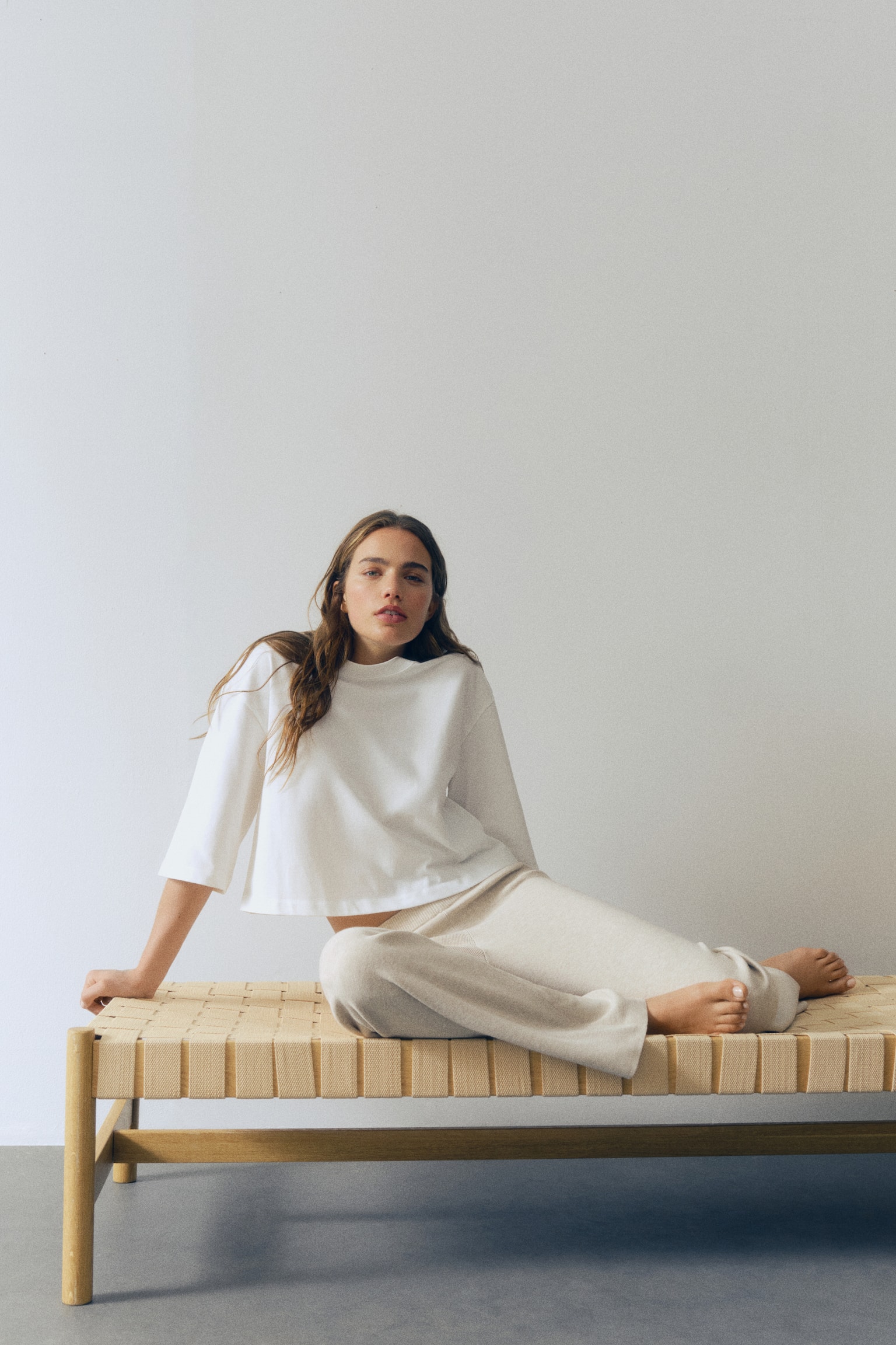 Le pantalon en maille beige clair présente une taille côtelée et des jambes larges. - 1
