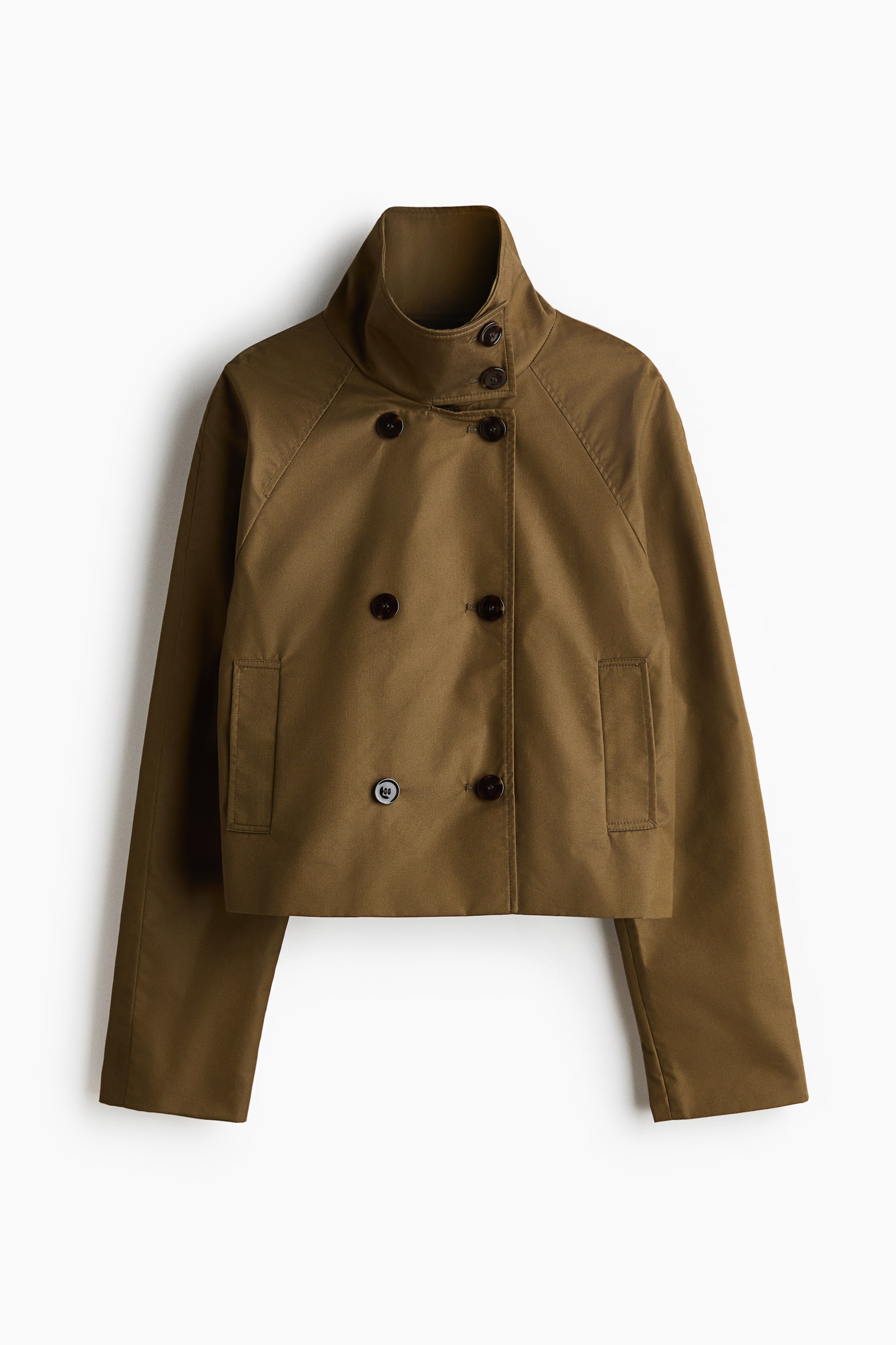 View larger image: An olive green cropped jacket featuring a high stand-up collar with two buttons and a double-breasted front adorned with six dark brown buttons. It showcases two rectangular patch pockets near the hem and long raglan sleeves.