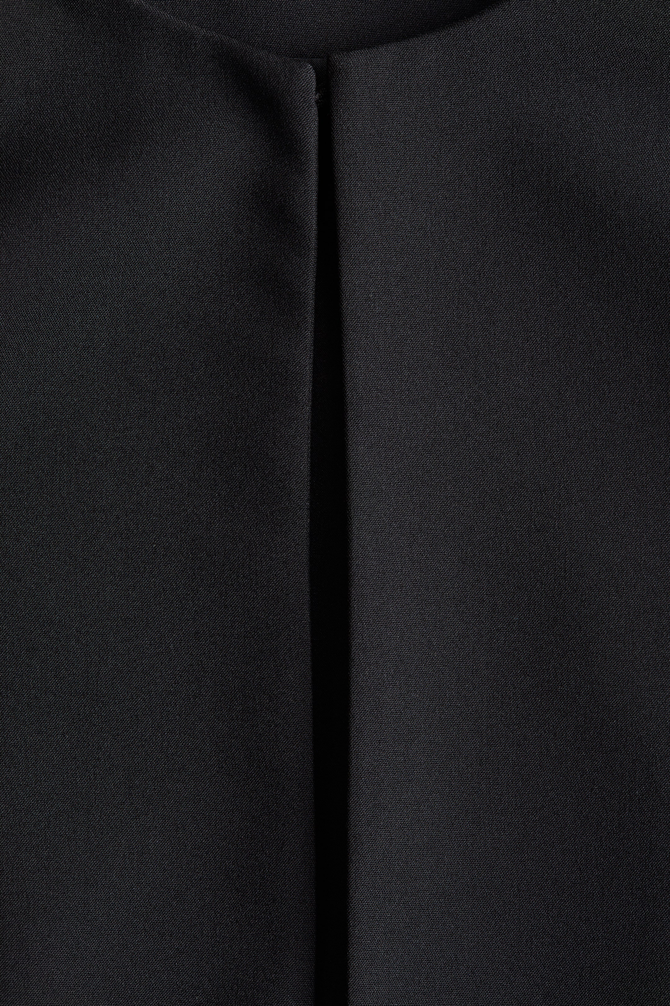 View larger image: The black woven fabric showcases a subtle texture on its front, with a central vertical pressed crease or seam running from top to bottom and a subtle horizontal seam visible at the top edge.