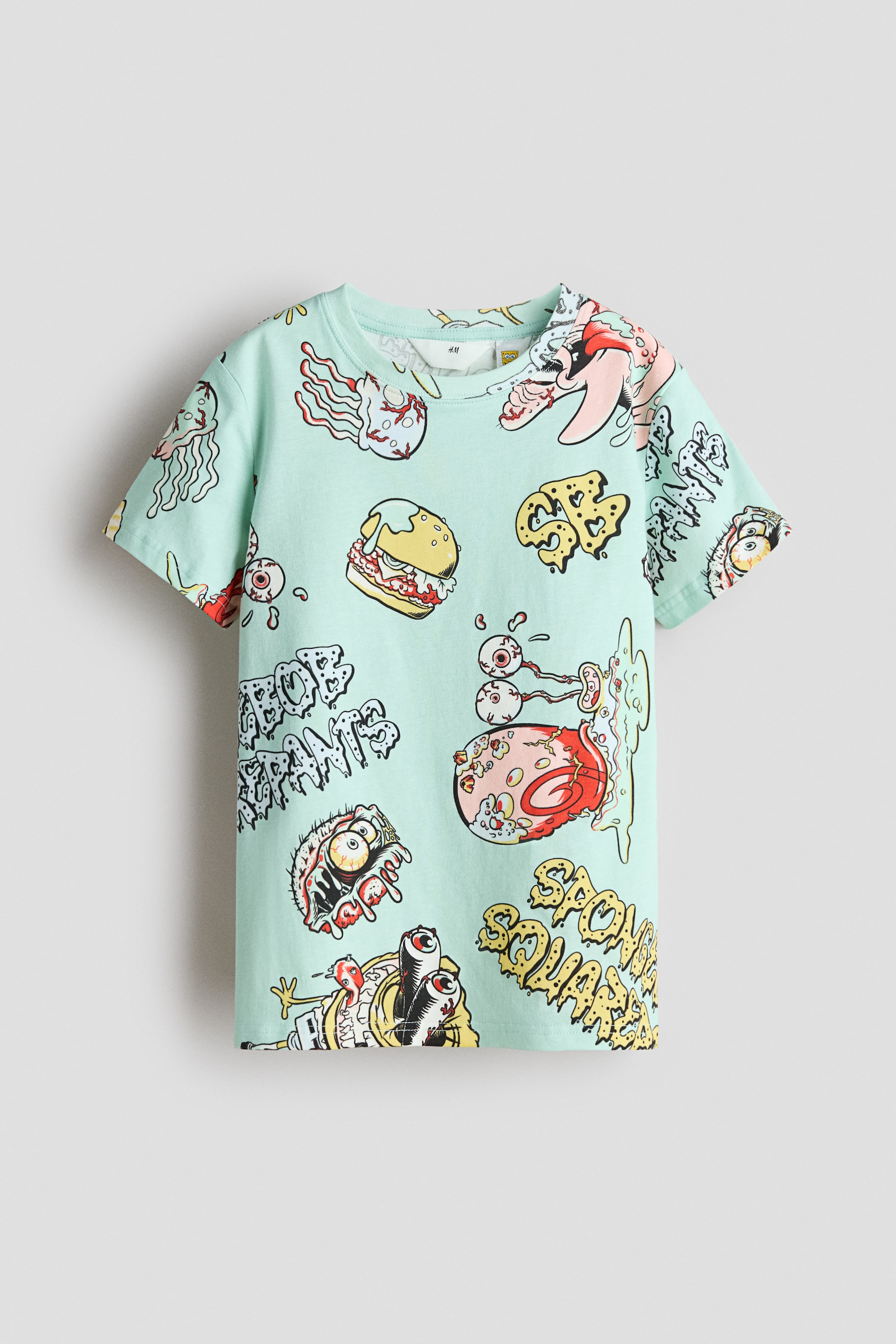 View larger image: A mint green t-shirt in soft, printed cotton jersey features a vibrant cartoon pattern across its front. Designed with a round, rib-trimmed neckline and dropped shoulders, it offers a relaxed yet stylish fit.