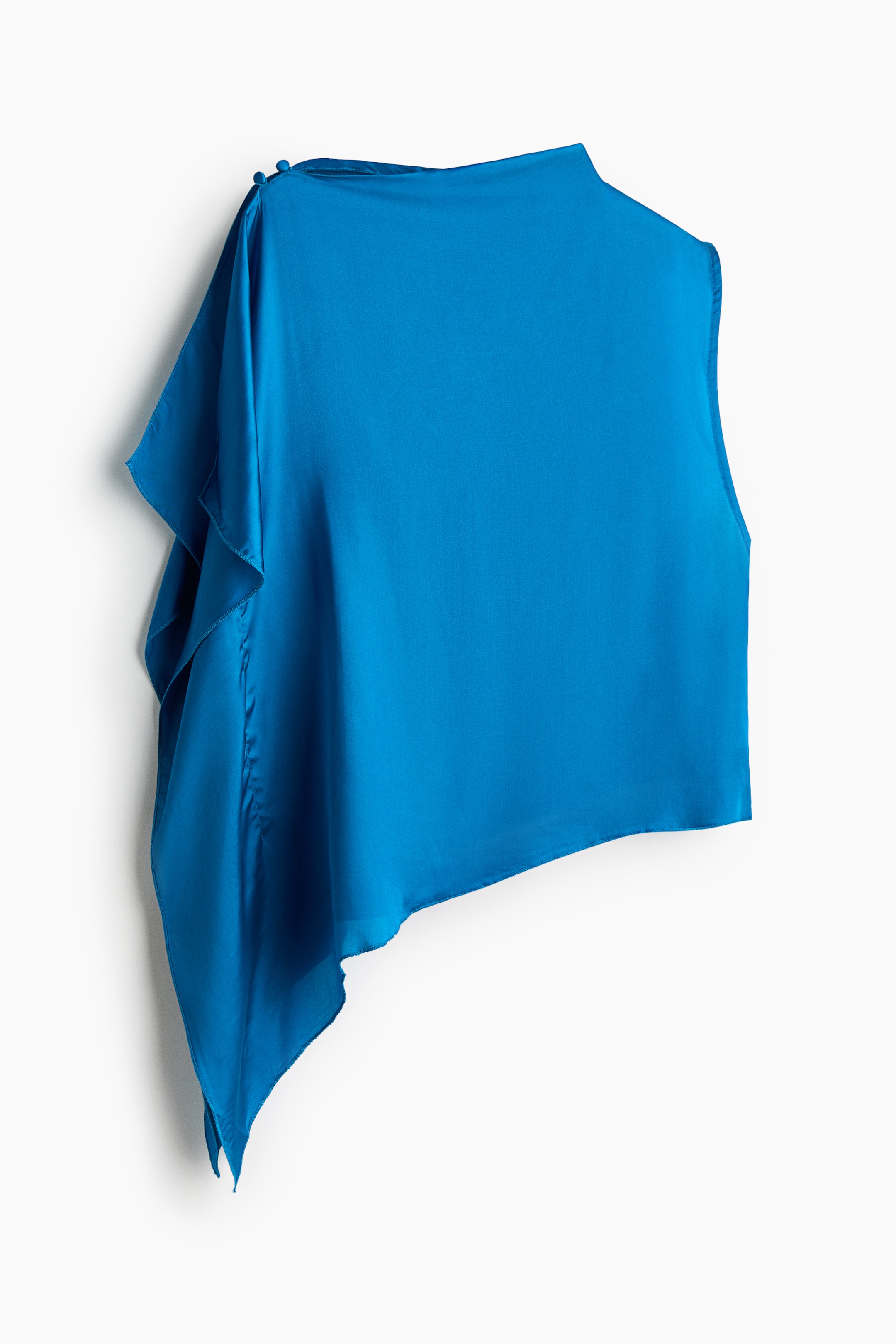 View larger image: A vibrant blue asymmetric top, crafted from a lustrous fabric, showcases a draped panel on the left shoulder, fastened by two small buttons. It features a high, finished neckline on the right side and an uneven hemline with a long, pointed drape on the lower left.