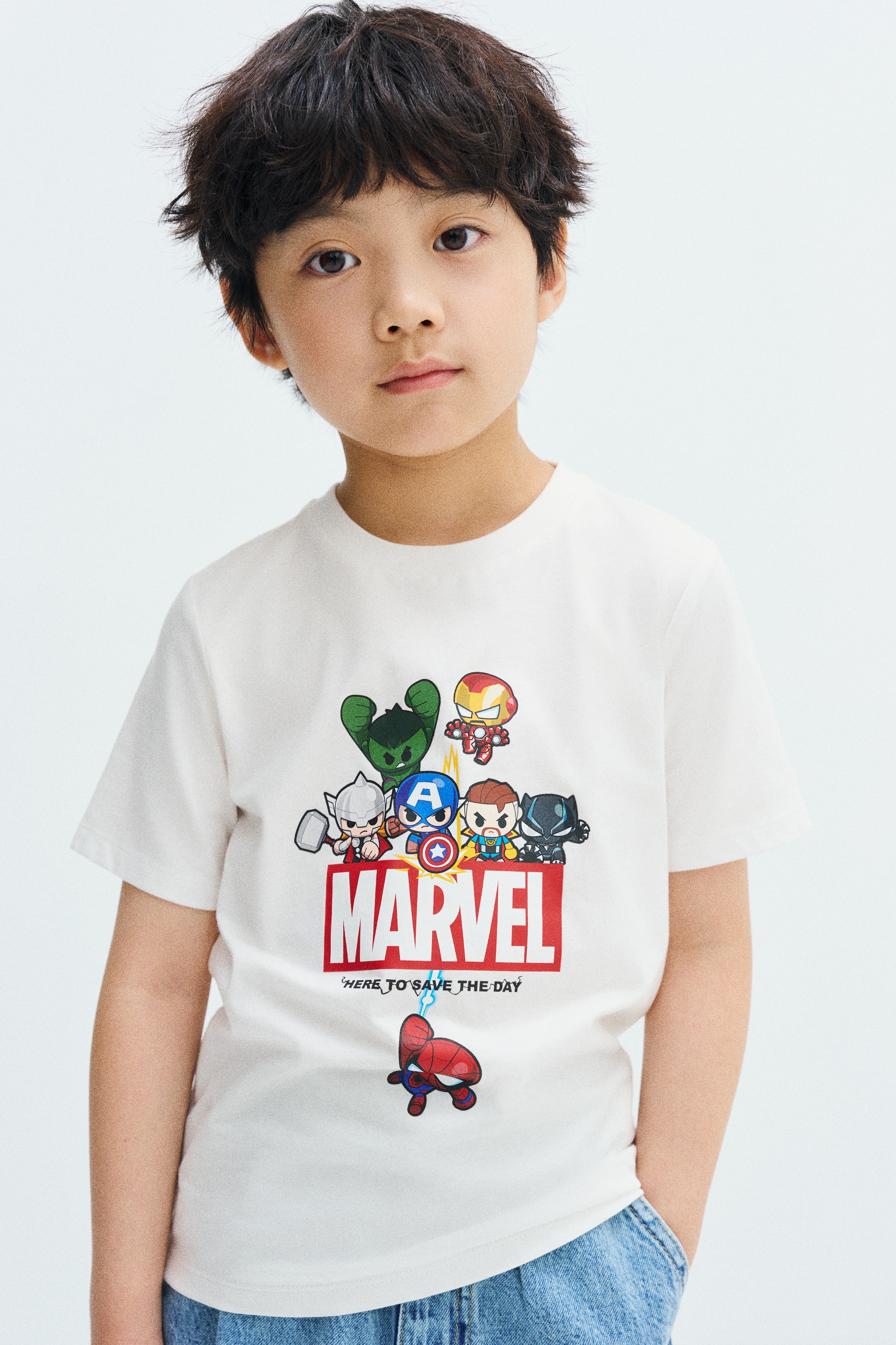 ä¸æ¬¾ç½è²ç­è¢åé  T æ¤ï¼æ­£é¢å°æå¡éé¢¨æ ¼ç Marvel è§è²åæ¡ãè§è²ç¾¤èæ¼éç®çç´è²ãMARVELãæ¨èªä¸æ¹ï¼ä¸¦æ­éãHERE TO SAVE THE DAYãå­æ¨£ï¼èèäººååææ¼ä¸æ¹ã