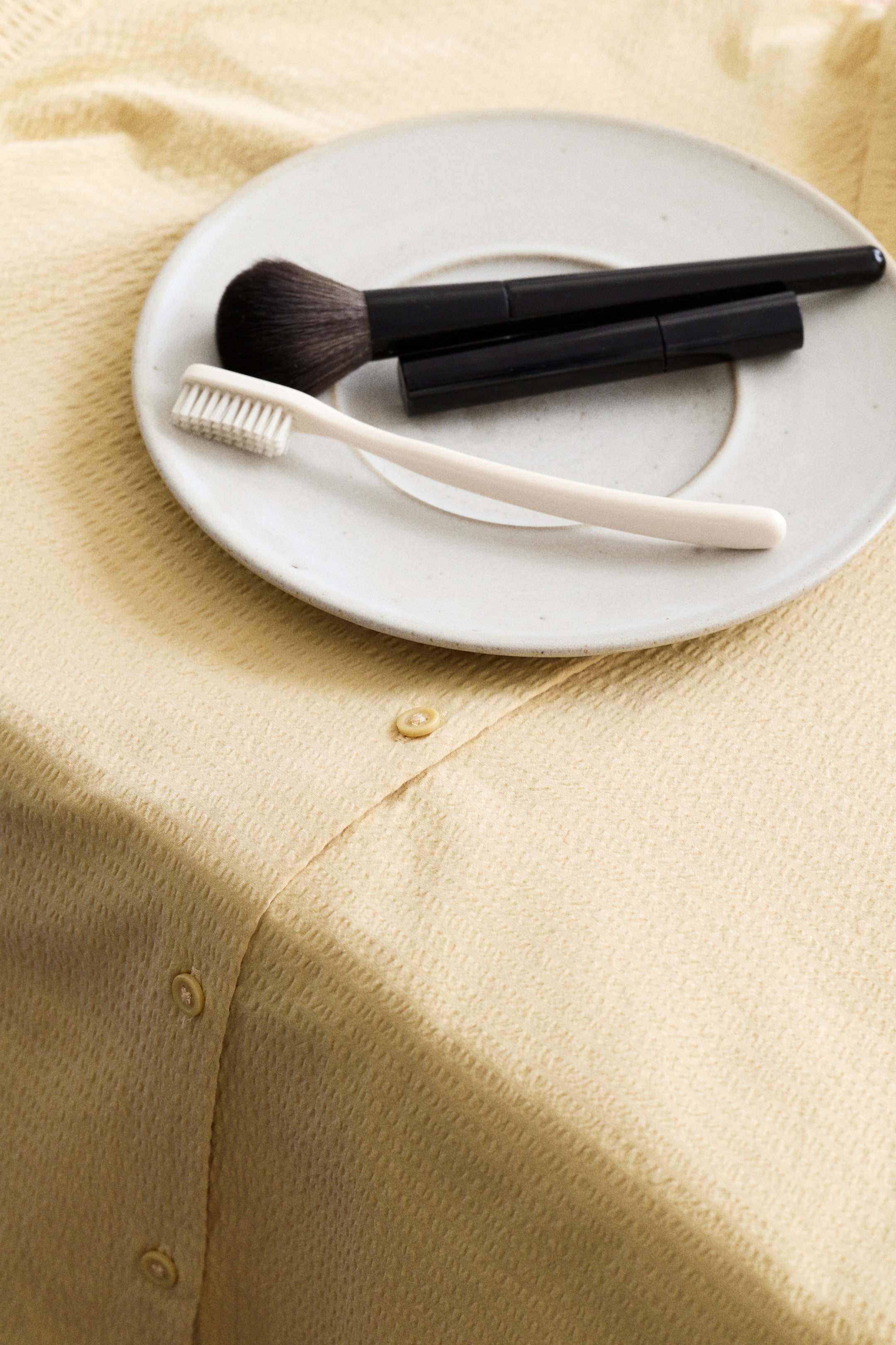 View larger image: Pyjamas comprising a shirt and shorts in breathable cotton seersucker, showcasing a light yellow shirt front. The shirt boasts a textured seersucker weave and a button-down placket with two visible buttons.