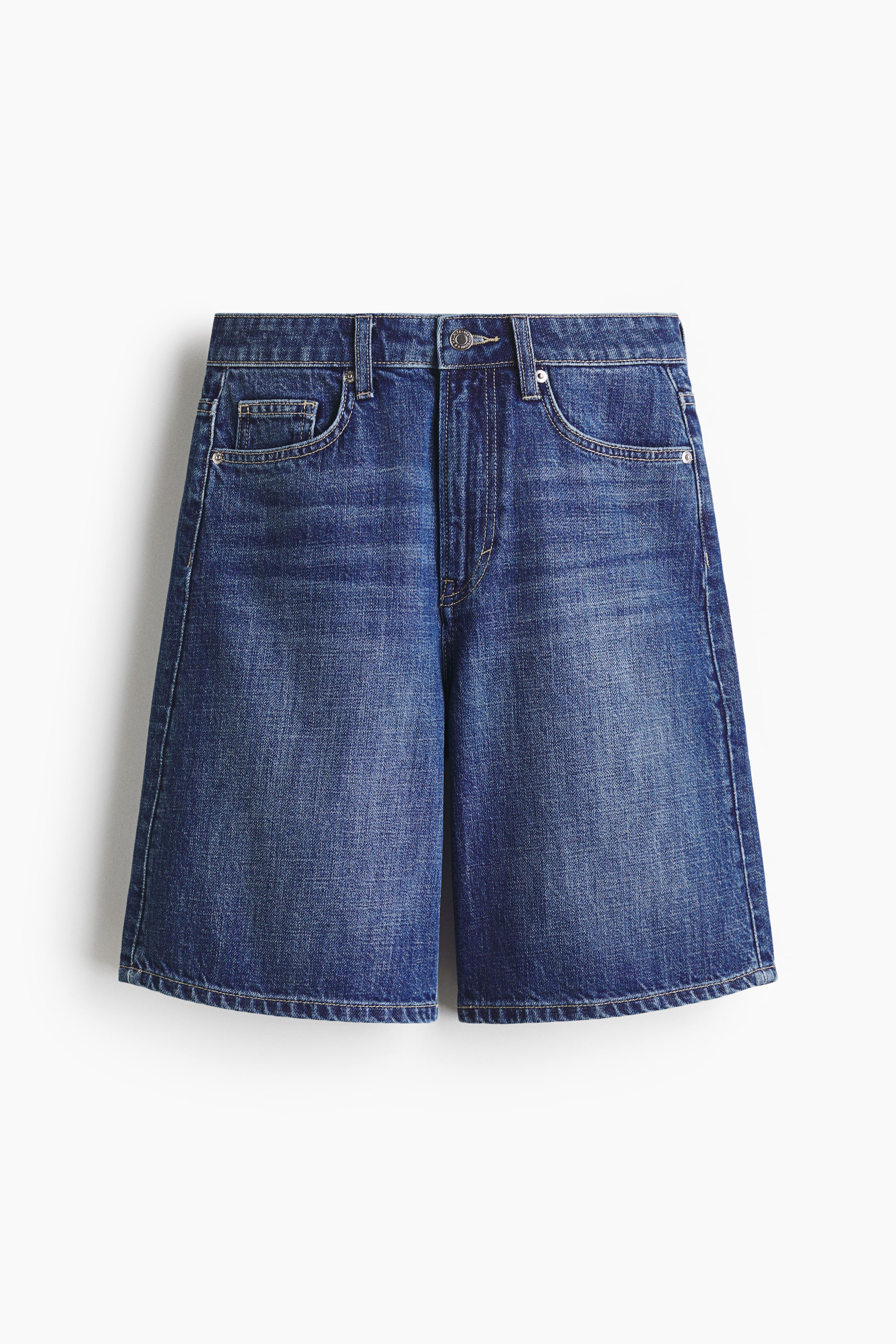 View larger image: These denim shorts showcase a medium blue wash with a high waist and a wide-leg cut that extends to the knee. They feature two curved front pockets, a coin pocket, metal rivets, belt loops, and a button and zipper fly.