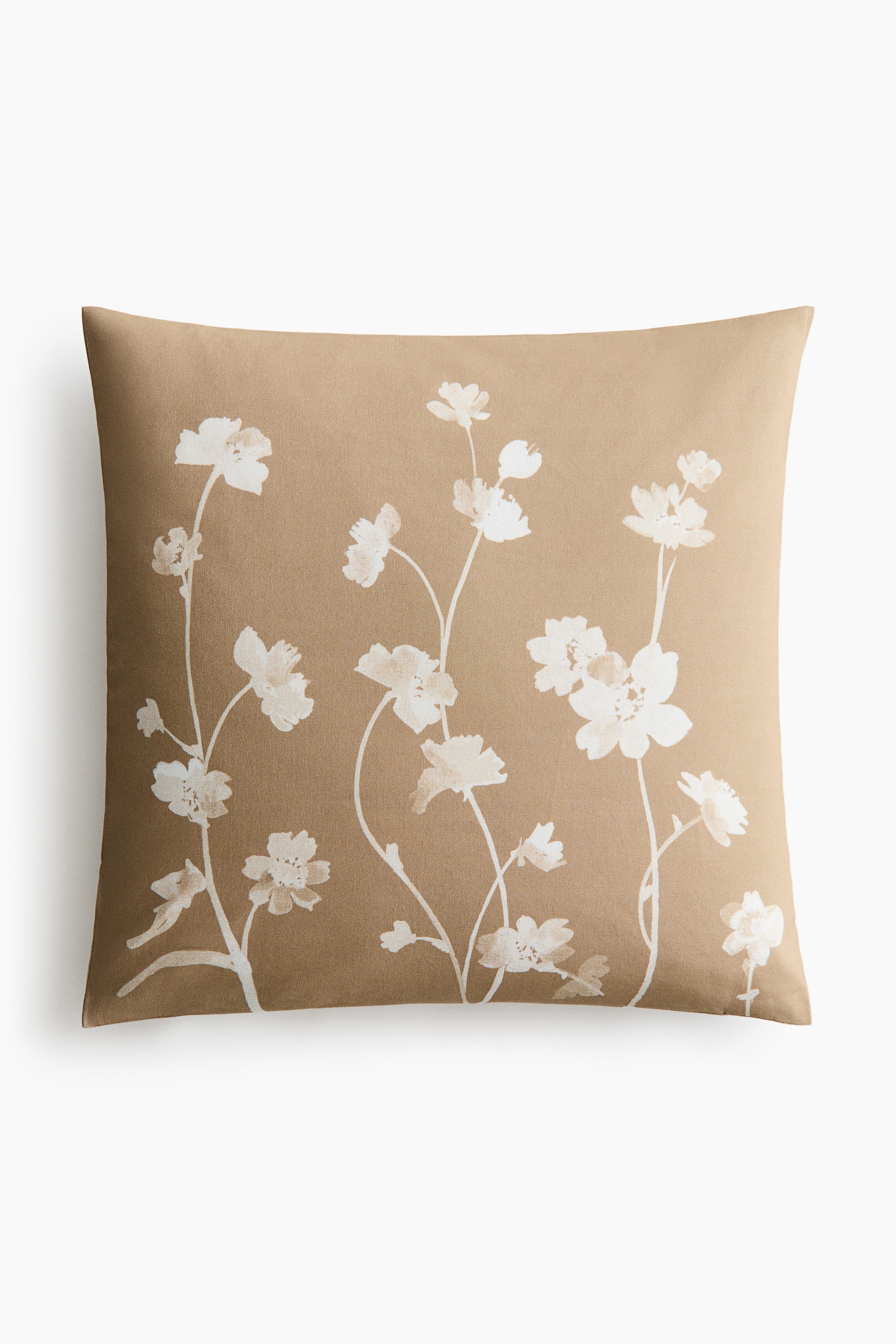 A cushion cover is facing front, showcasing a botanical print of white flowers and stems on a tan cotton canvas.