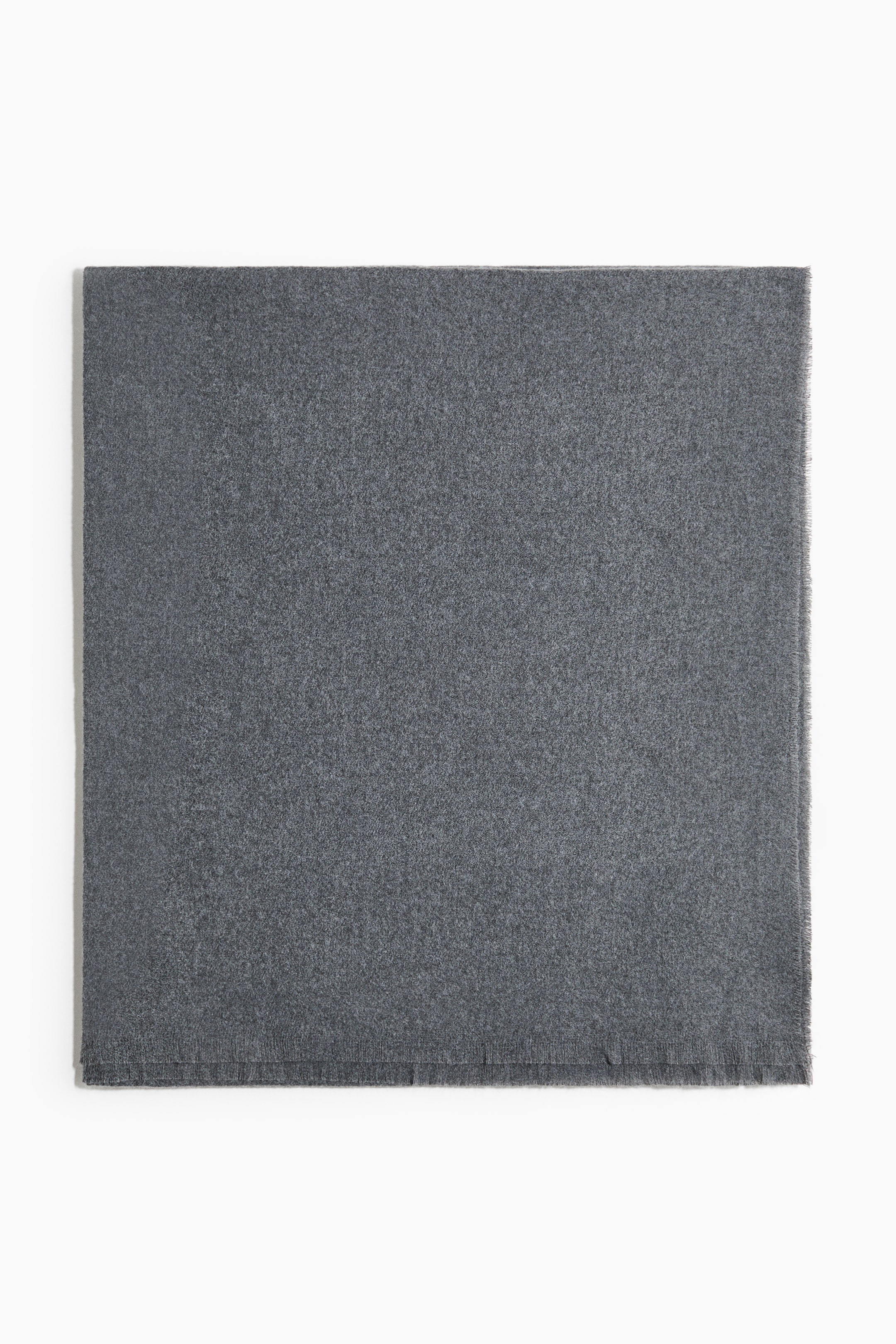 View larger image: A dark grey rectangular scarf is lying flat, displaying a soft, subtly textured surface. Its top and left edges appear clean, while the right and bottom edges feature a visible fringe.