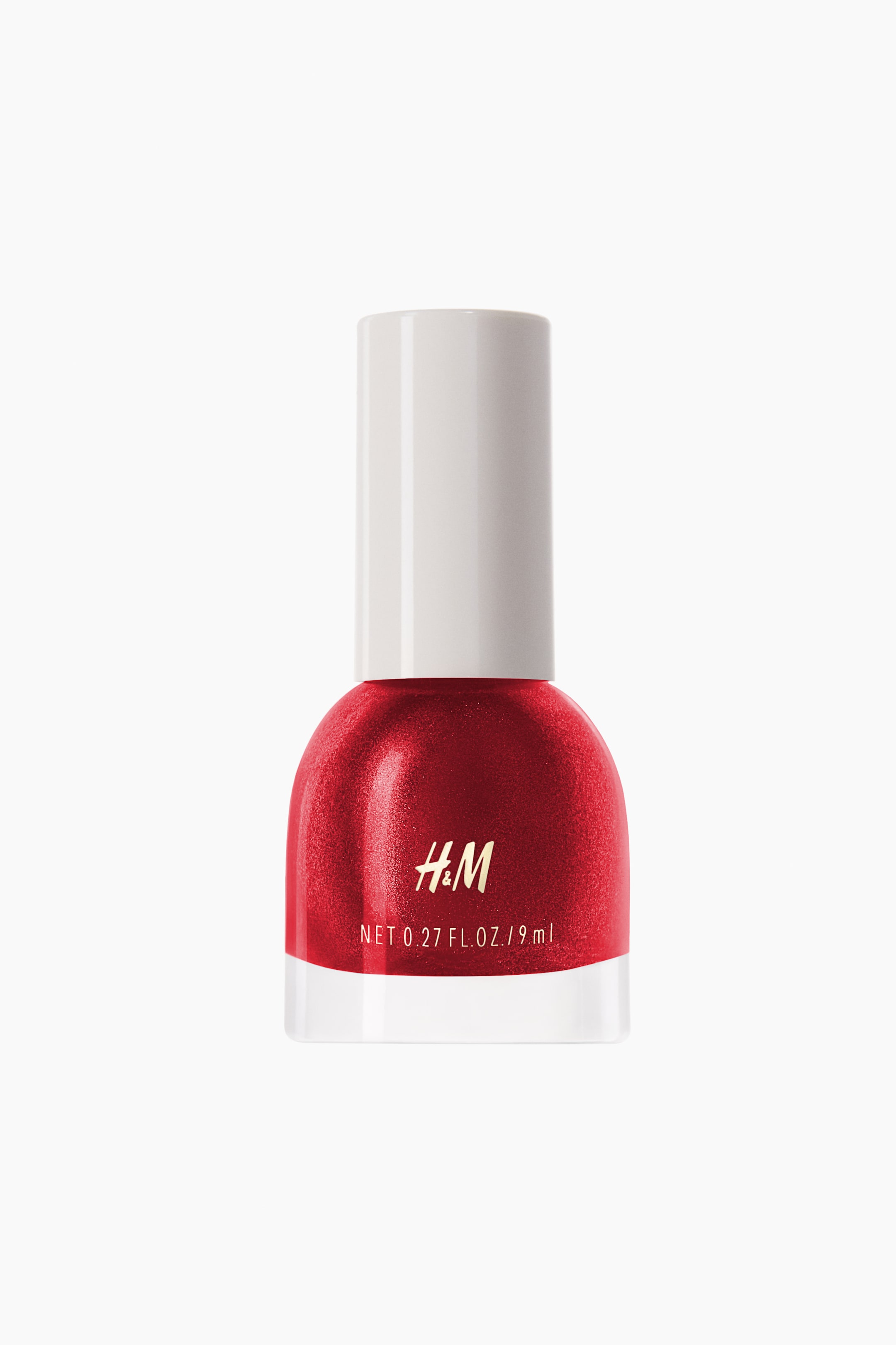 View larger image: The nail polish bottle showcases a gleaming red lacquer encased in its transparent, rounded glass vessel. A white cylindrical cap crowns the bottle, with gold H&M branding and volume specifications prominently displayed on the front.
