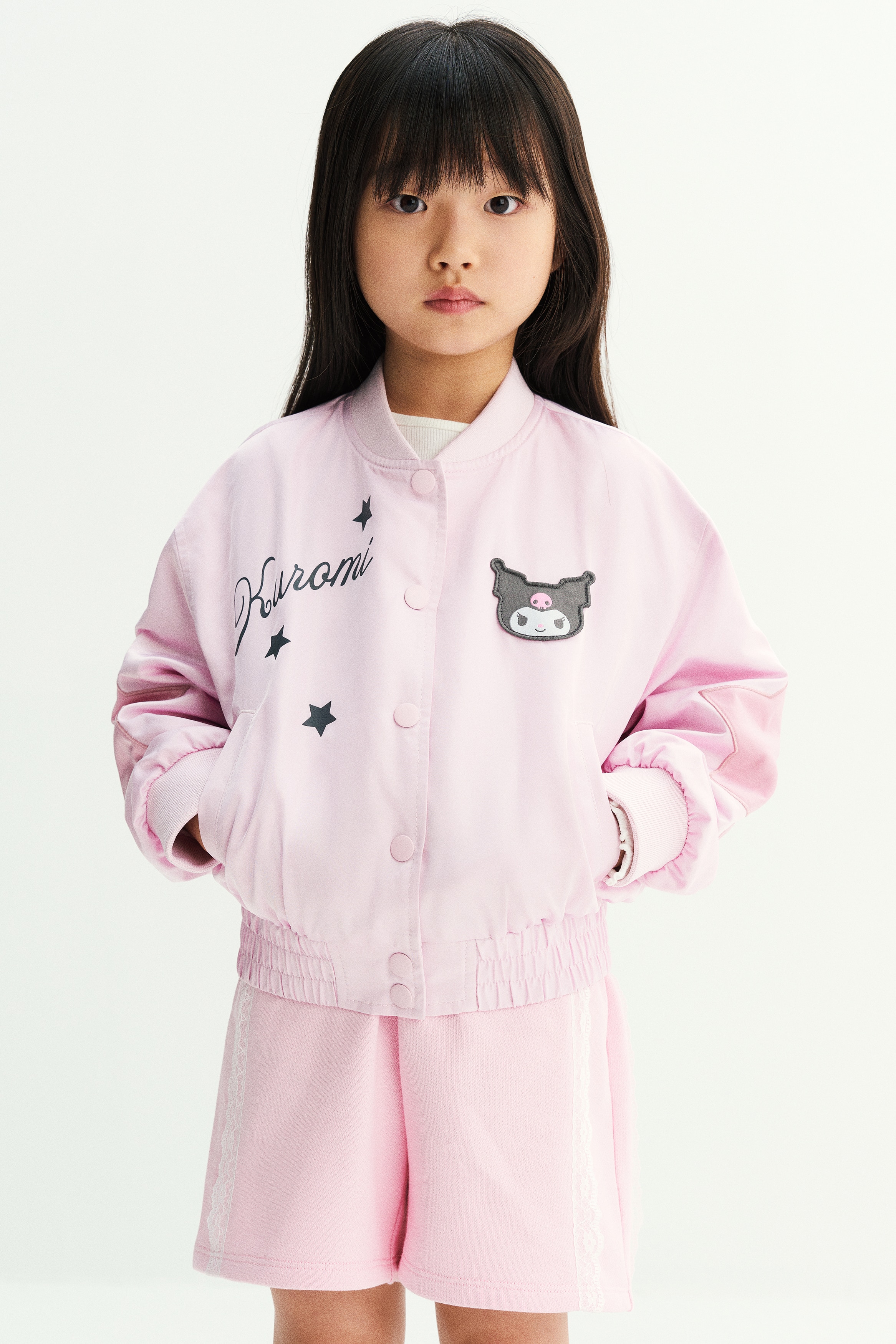 Má»t chiáº¿c quáº§n short len mÃ u há»ng nháº¡t ÄÆ°á»£c chá»¥p tá»« phÃ­a trÆ°á»c, cÃ³ cáº¡p chun nhÃºn vÃ  cÃ¡c máº£ng ren tráº¯ng cháº¡y dá»c hai bÃªn.