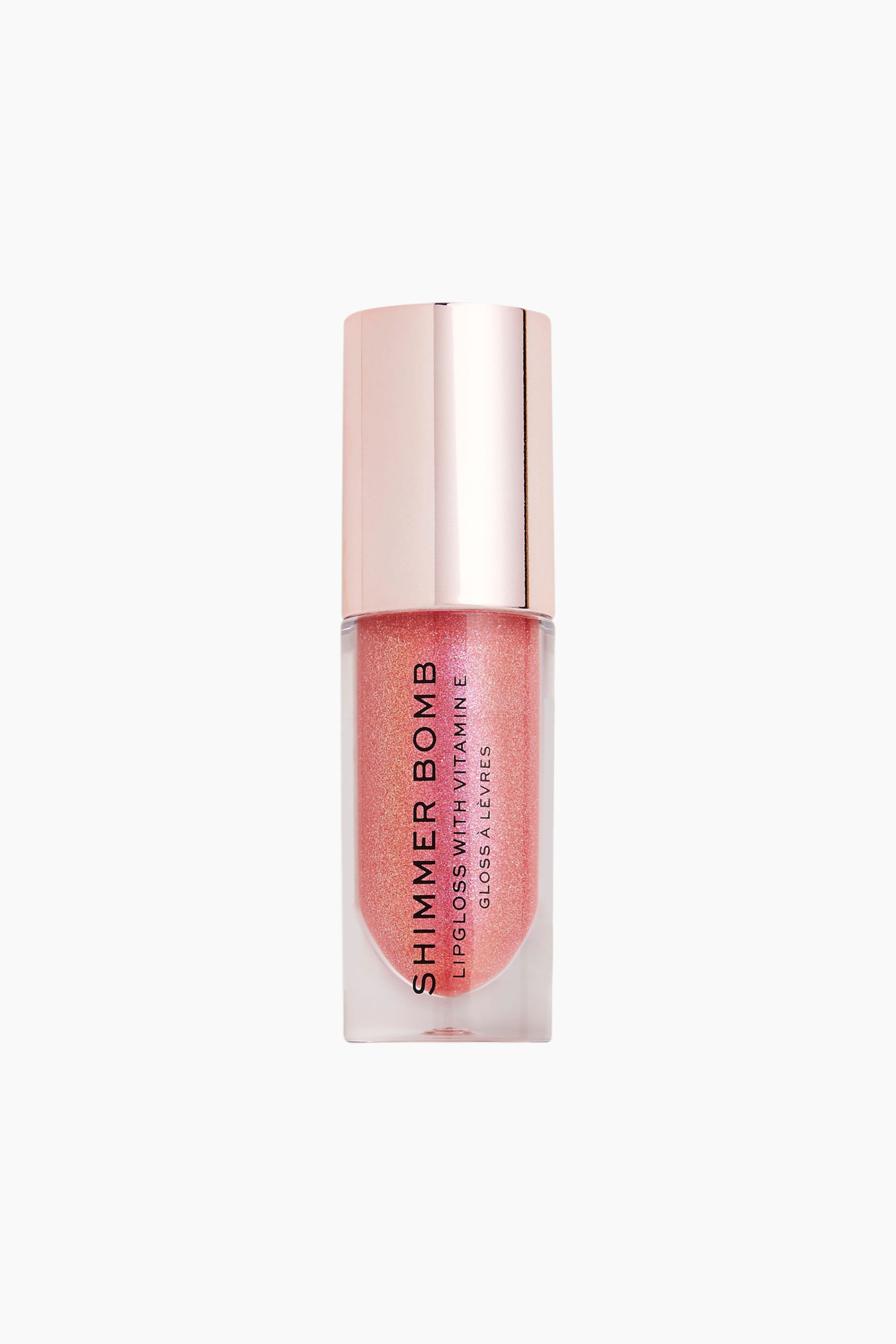 Größeres Bild ansehen: Ein Lipgloss-Tube steht aufrecht und zeigt eine transparente, zylindrische Flasche, die mit einem schimmernden, pfirsichrosa Gloss gefüllt und mit einer metallisch roségoldenen Kappe versehen ist. Schwarzer Text mit der Aufschrift „SHIMMER BOMB“ verläuft vertikal über die Vorderseite des transparenten Behälters.