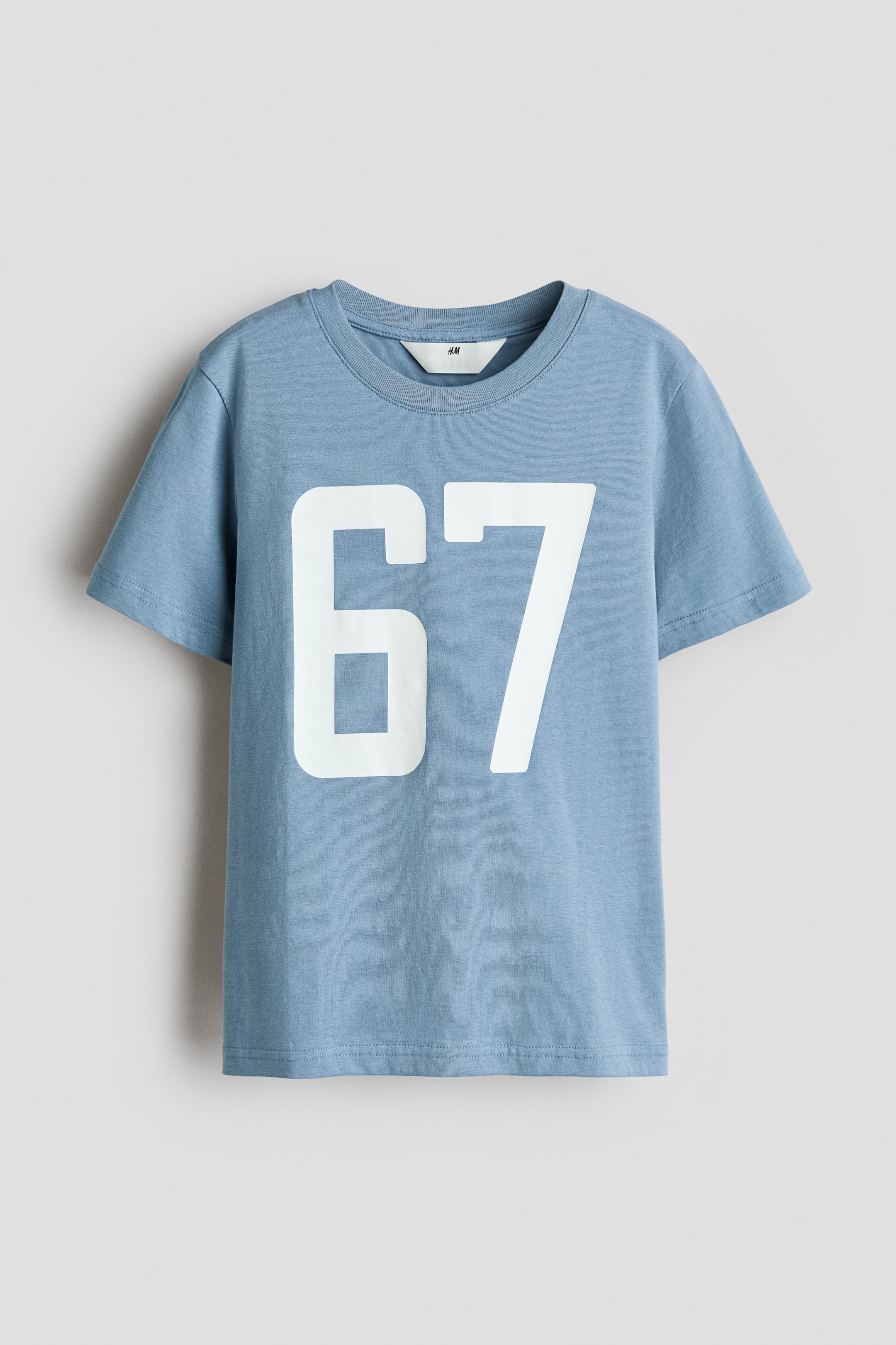 View larger image: The light blue T-shirt is shown from the front, showcasing a large white "67" print on the chest. It features a ribbed crew neckline and short sleeves.