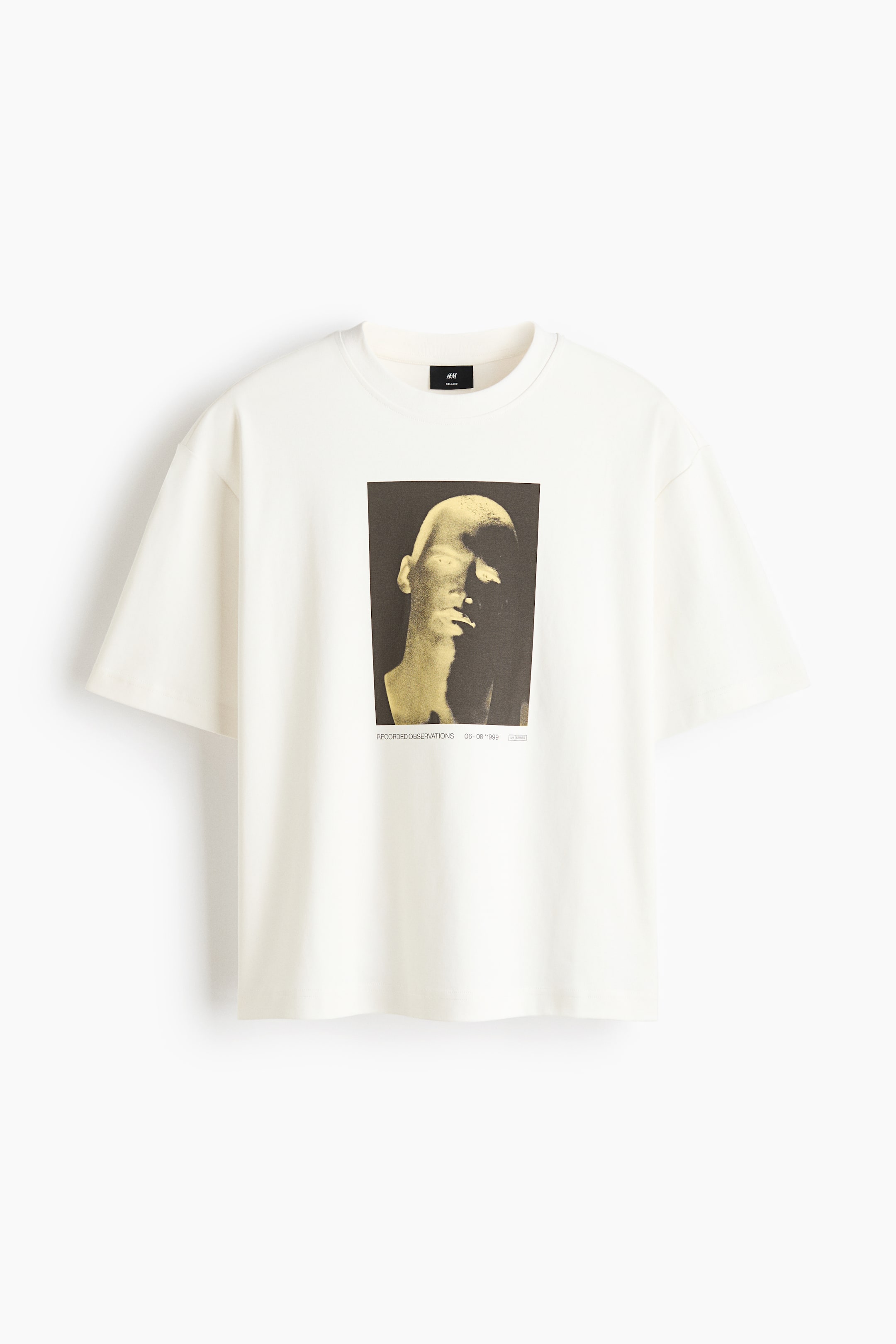 View larger image: A front view of an off-white, boxy-style t-shirt with a relaxed fit features a round, ribbed neckline, dropped shoulders, and a straight-cut hem. This heavyweight cotton jersey t-shirt showcases a central rectangular print motif depicting a stylized head with light highlights and small text underneath.