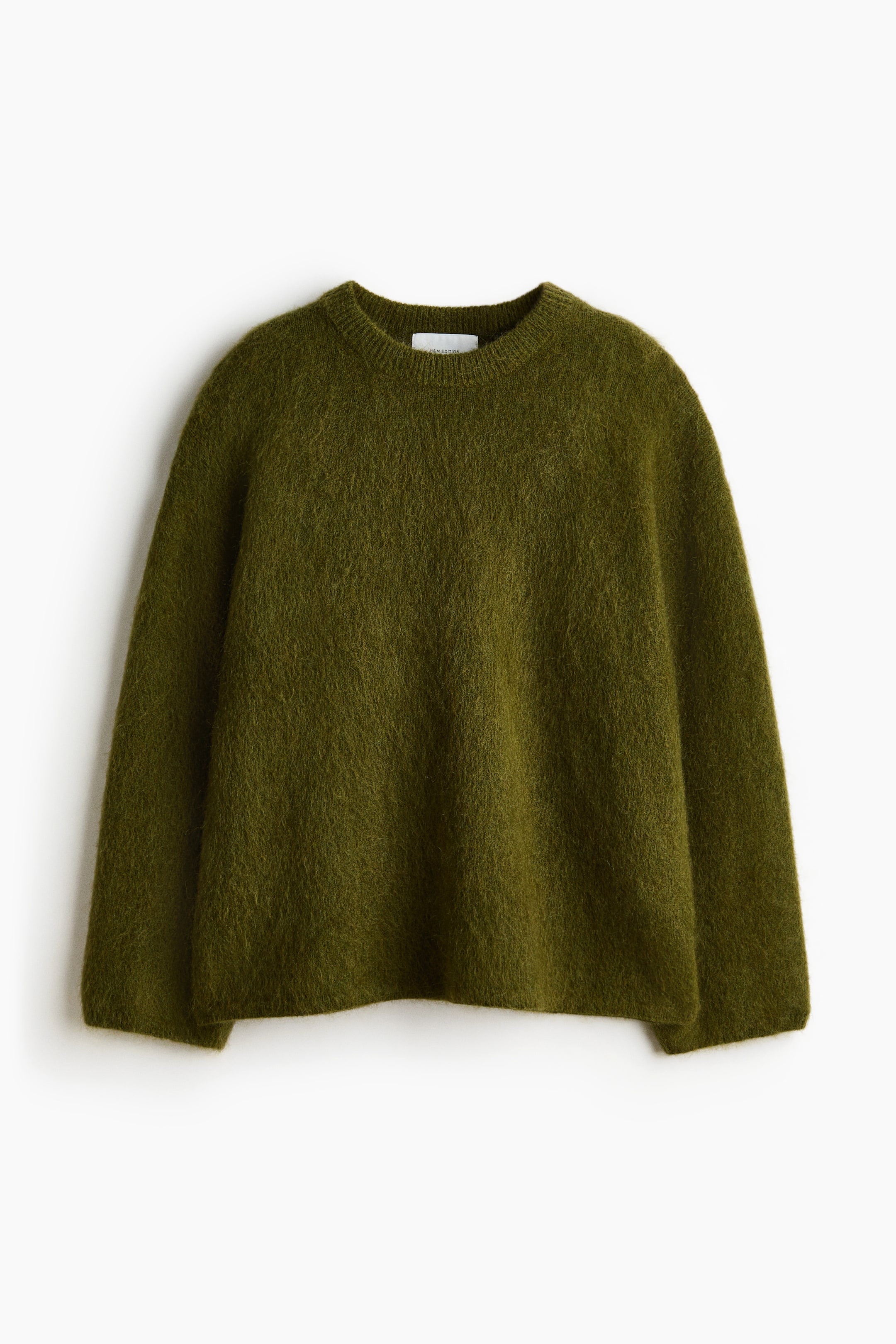 Voir une image plus grande: Un chandail ample vert olive est présenté de face, mettant en valeur une texture tricotée douce et duveteuse. Il présente des épaules tombantes, des manches longues et des détails côtelés au col rond, aux poignets et à l'ourlet.