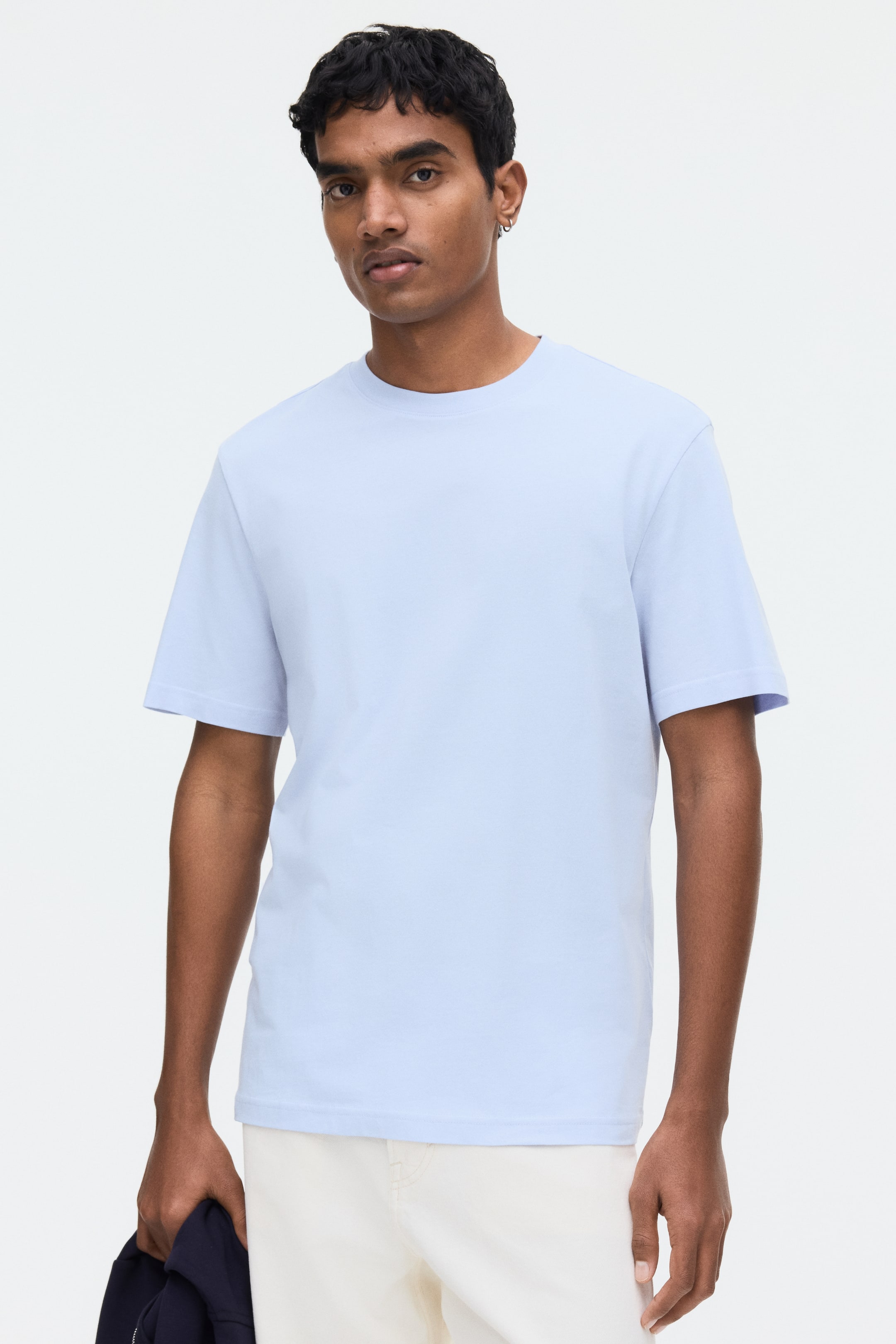 View larger image: A light blue t-shirt features a ribbed crew neck, short sleeves, and a straight hem. It fits with a relaxed silhouette on the torso and is facing forward.