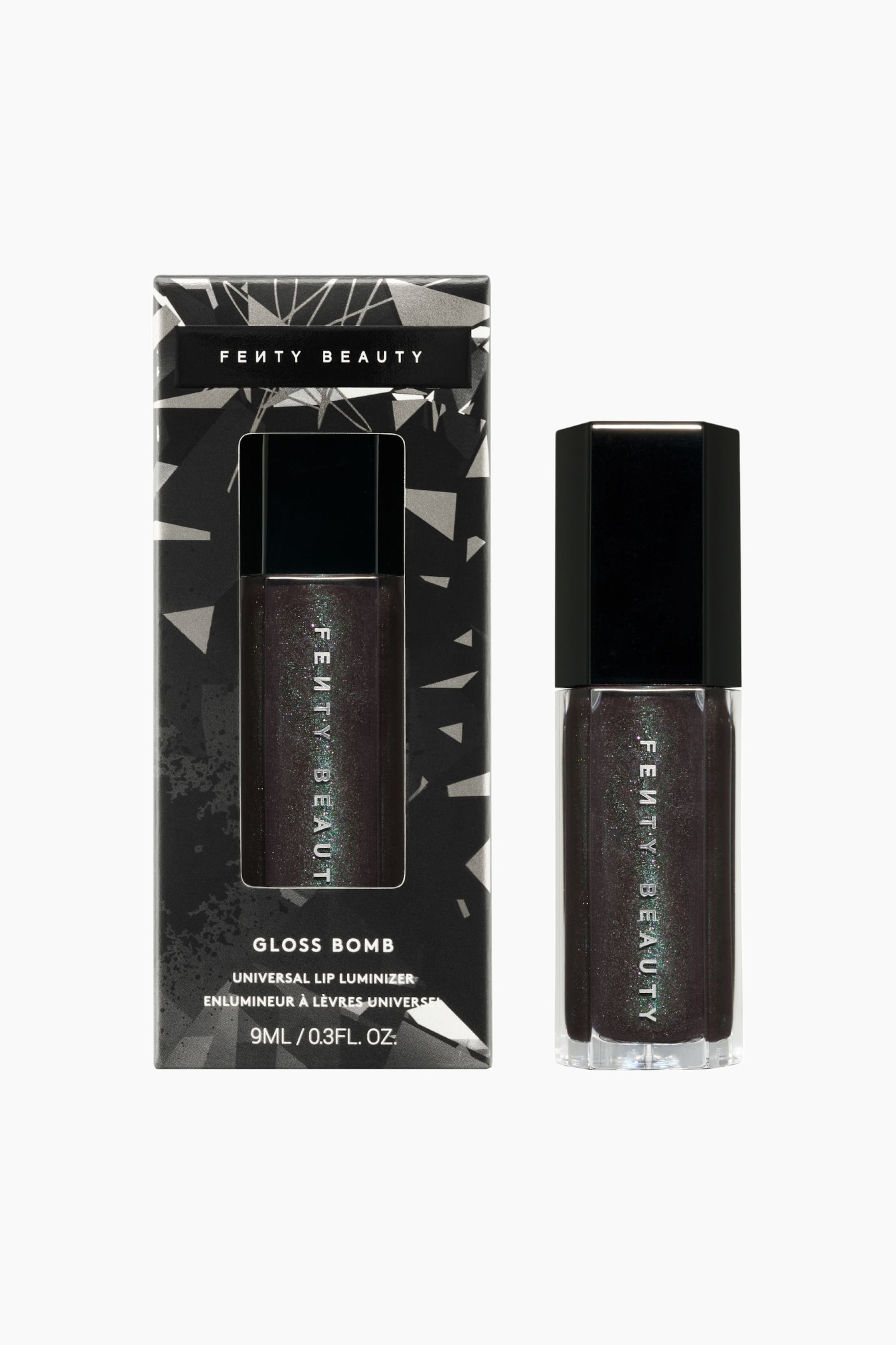 Visa större bild: Limited Edition Gloss Bomb Universal Lip Luminizer står upprätt bredvid sin rektangulära förpackningsask, båda vända rakt framåt. Den sexkantiga genomskinliga flaskan visar upp ett mörkt, skimrande kolgrått läppglans med fint grönt mikroskimmer, med en glansig svart sexkantig kork och vertikal vit branding. Den matchande svart- och silverfärgade geometriska asken visar produktnamnet, detaljerna och ett tydligt fönster som avslöjar glansen inuti.